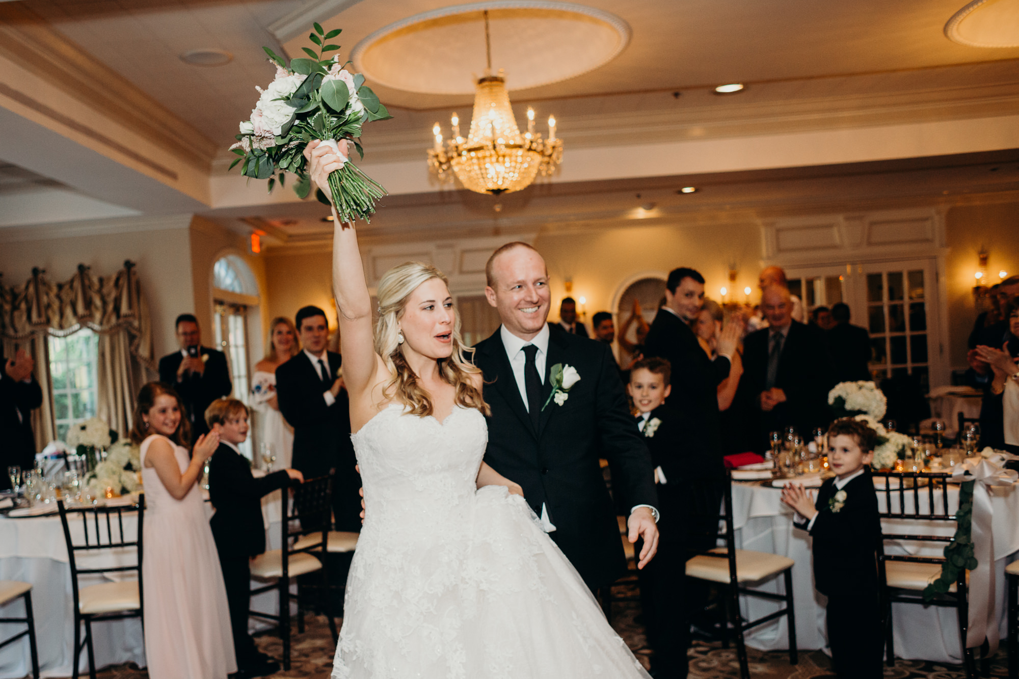 a bride and groom enter their reception at the upper montclair country club in montclair, new jersey