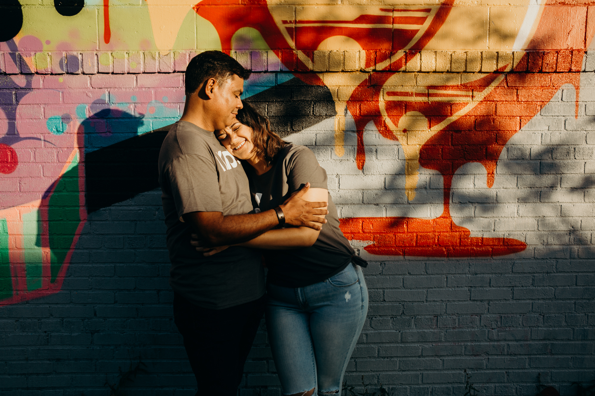 a couple stands in front of a mural in bushwick, brooklyn