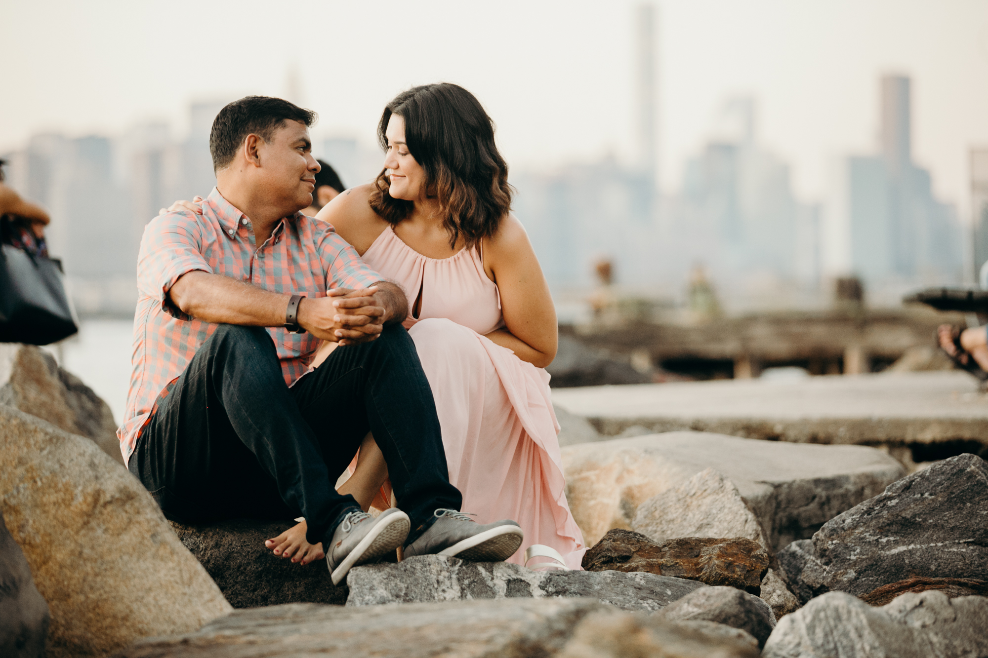 a portrait of a couple on the waterfront facing manhattan in williamsburg, brooklyn