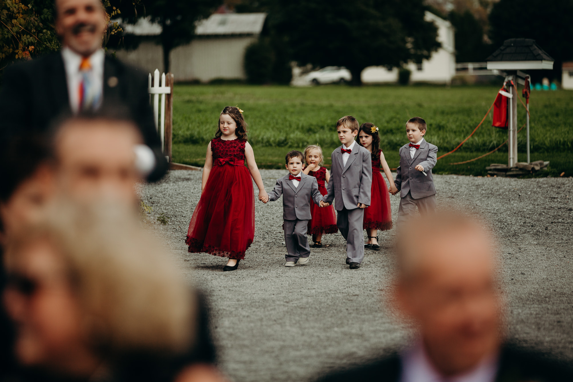 kids walk down the aisle during a wedding ceremony at hayloft on the arch in syracuse, new york