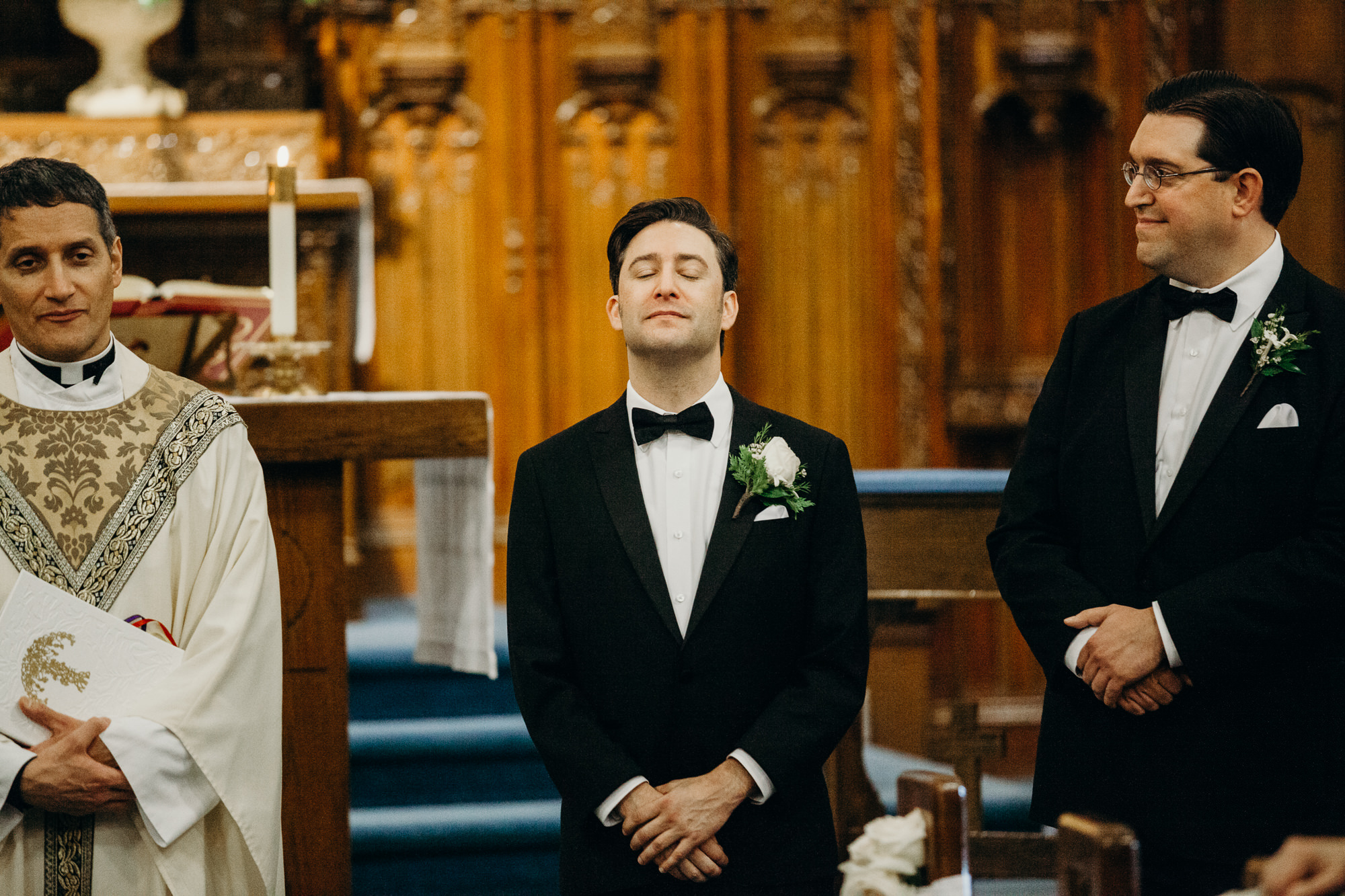 a groom waits to see his bride walk down the aisle at a church in rochester, ny