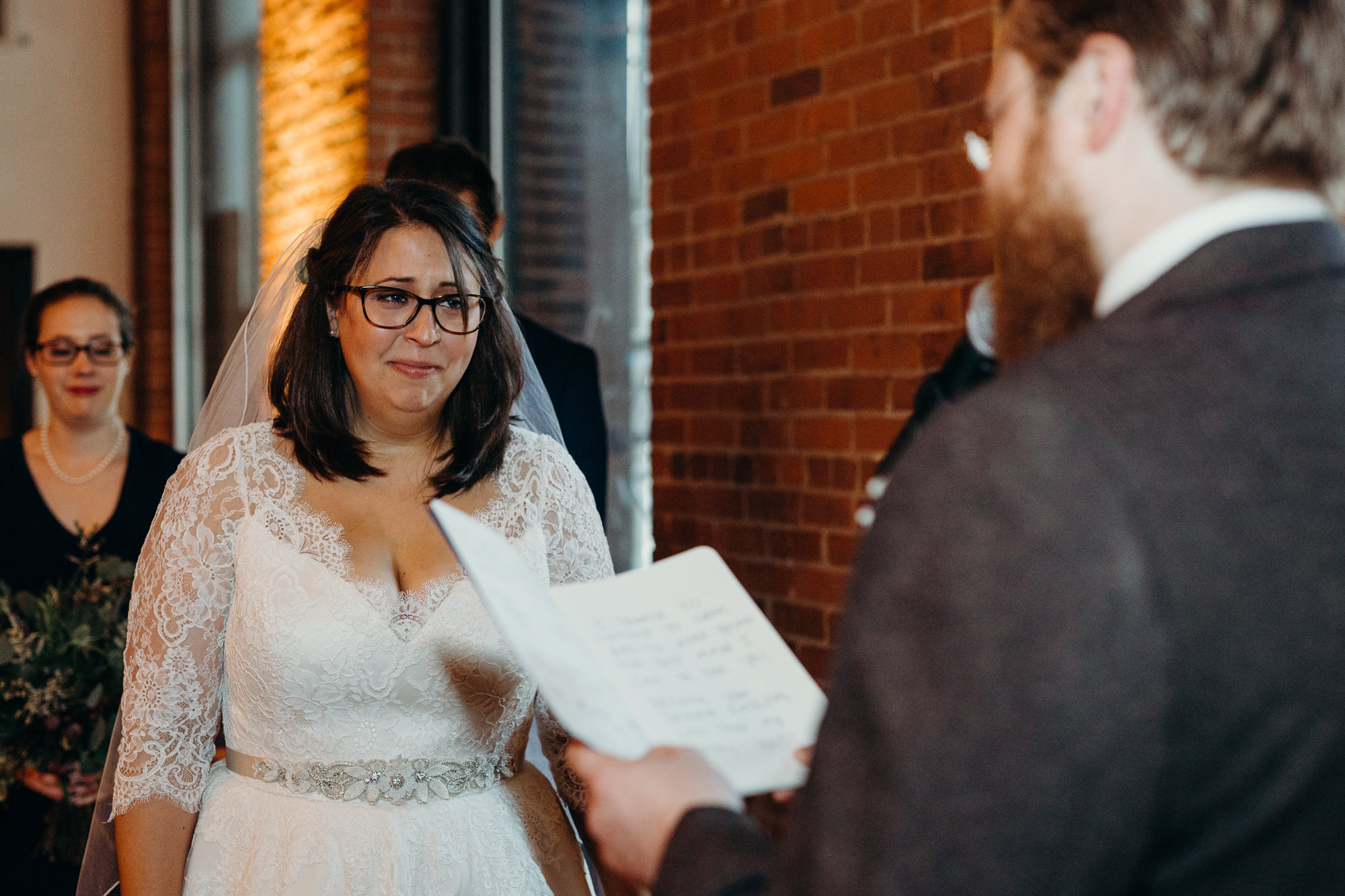 a bride wipes away tears during her wedding vows at dumbo loft in brooklyn, ny