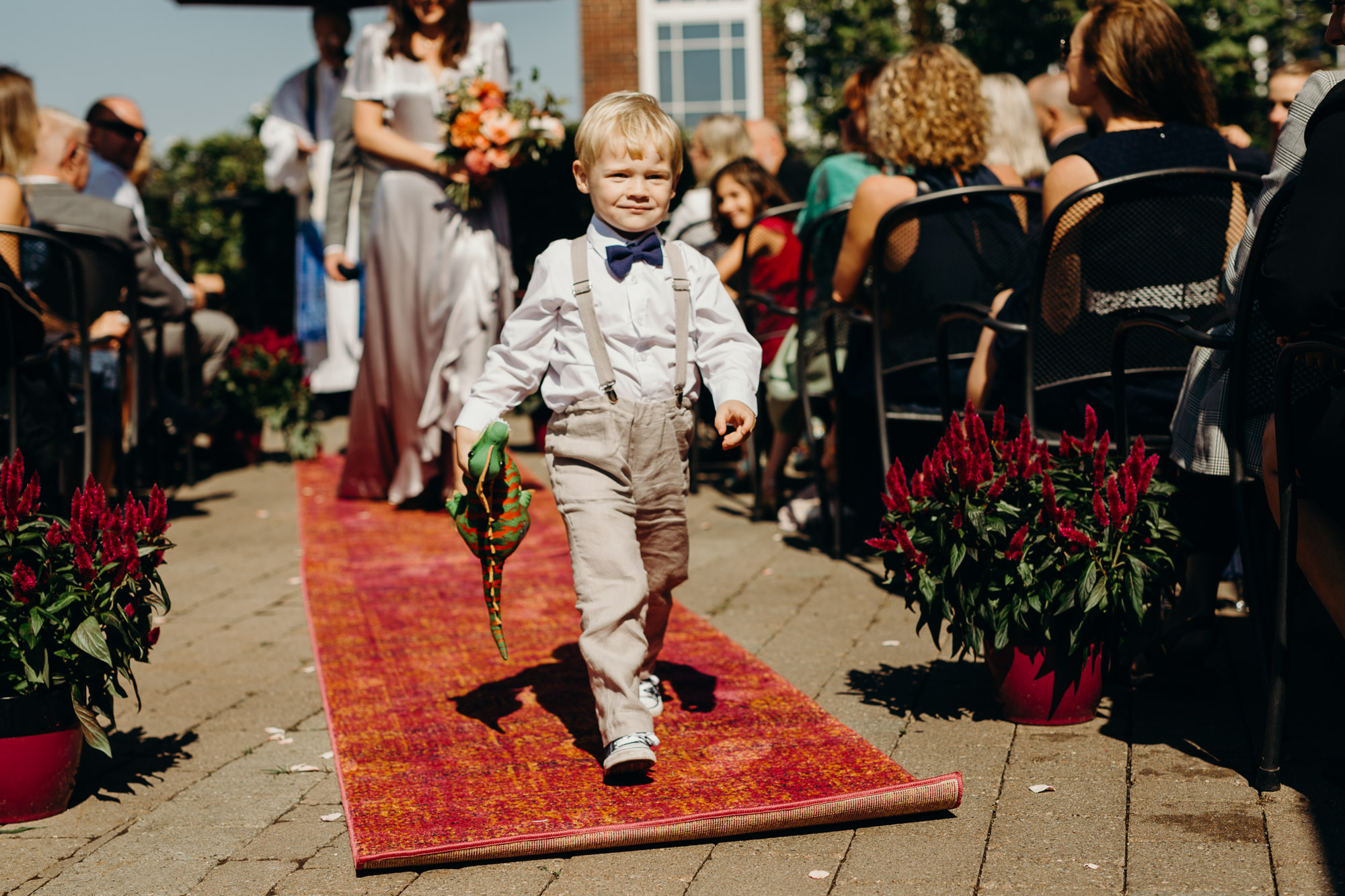 a ring bearer walks down the aisle at the end of a wedding at red hat on the river in new york, ny