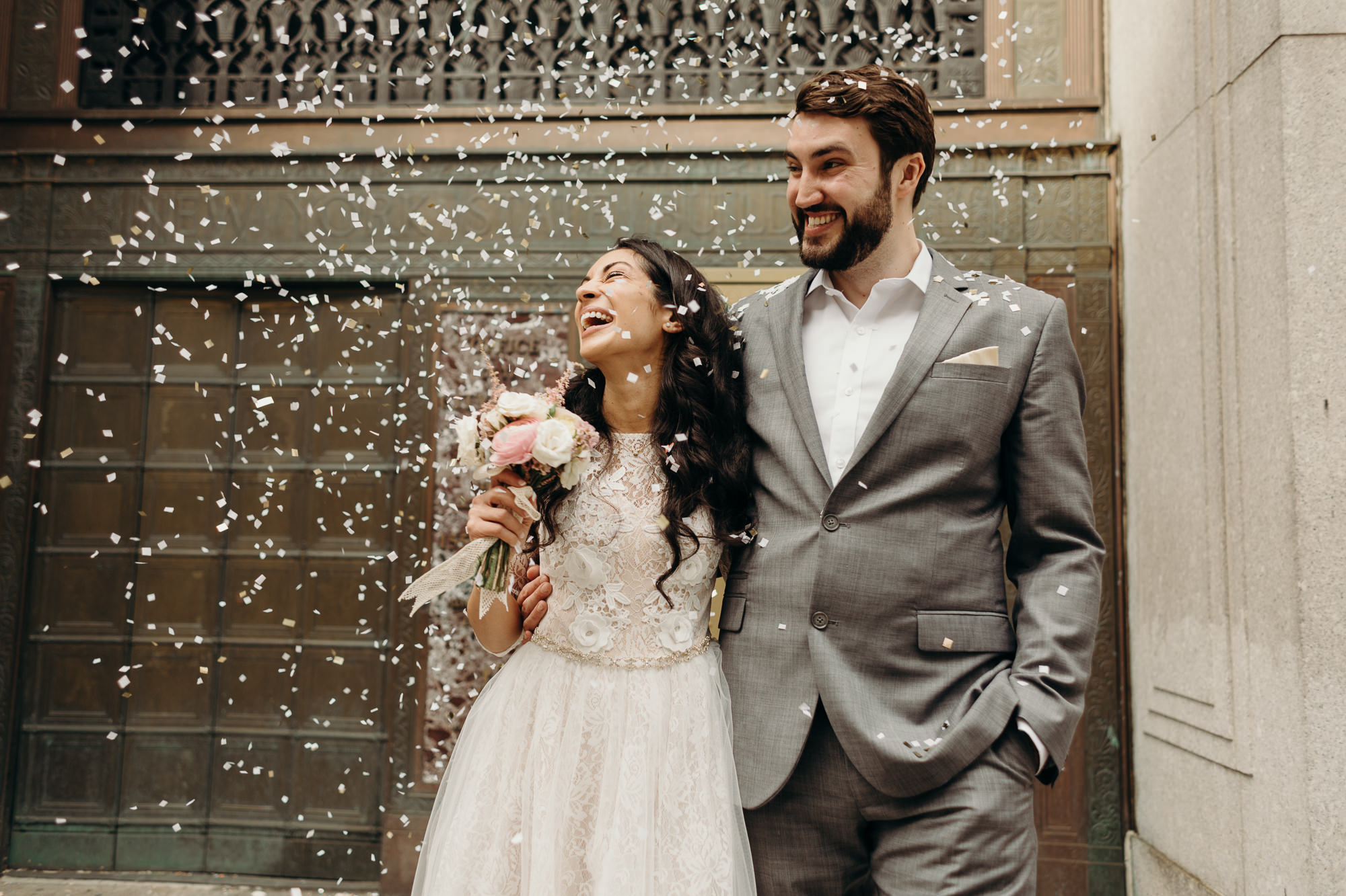 a bride and groom celebrate with confetti after their wedding ceremony at city hall in new york city, ny
