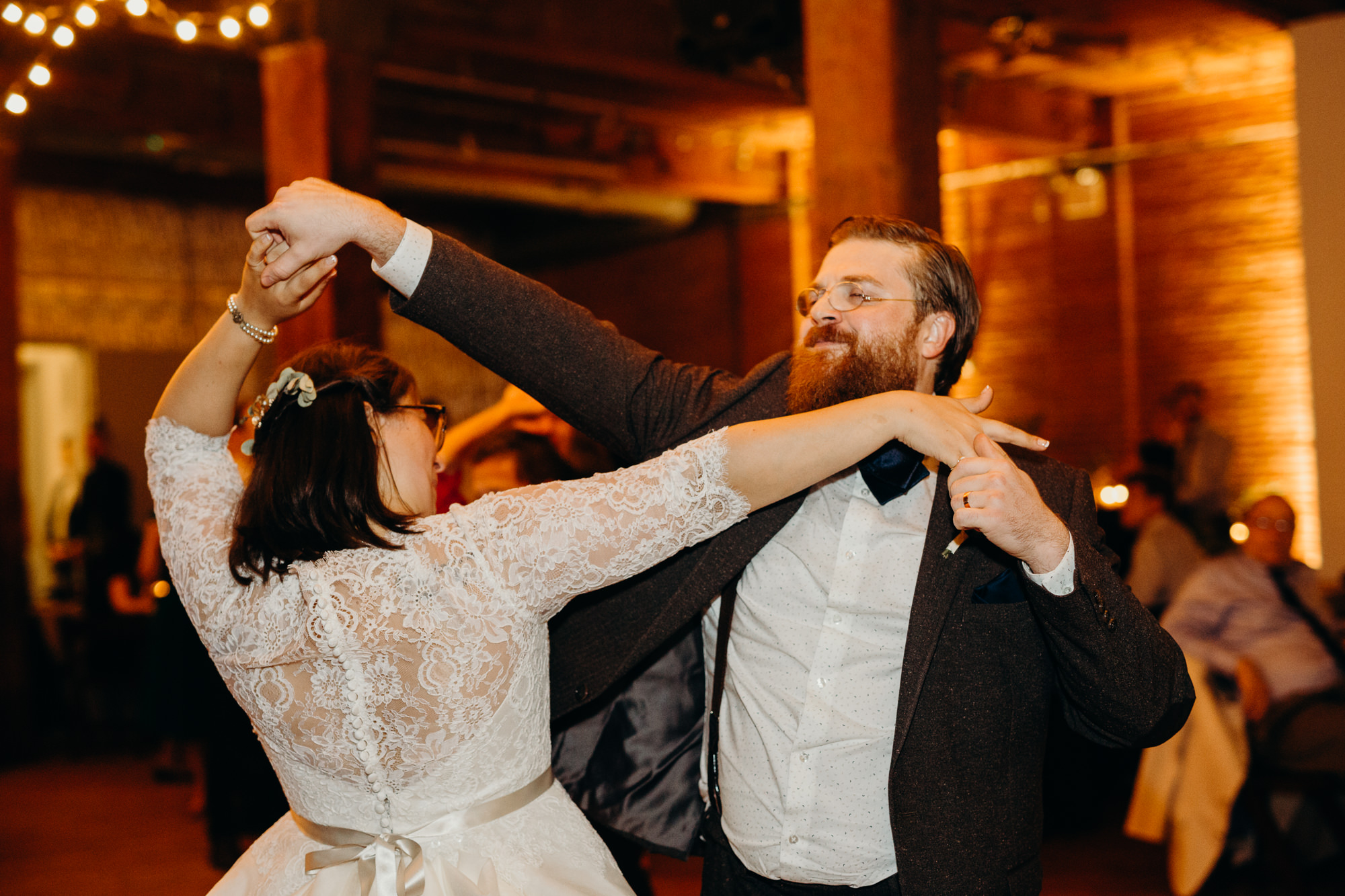 a bride and groom dance together during their wedding reception at dumbo loft in brooklyn, ny