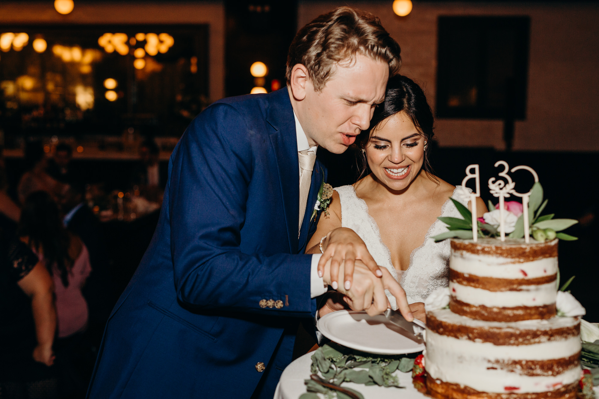 a bride and groom cut their wedding cake at 501 union in brooklyn, ny