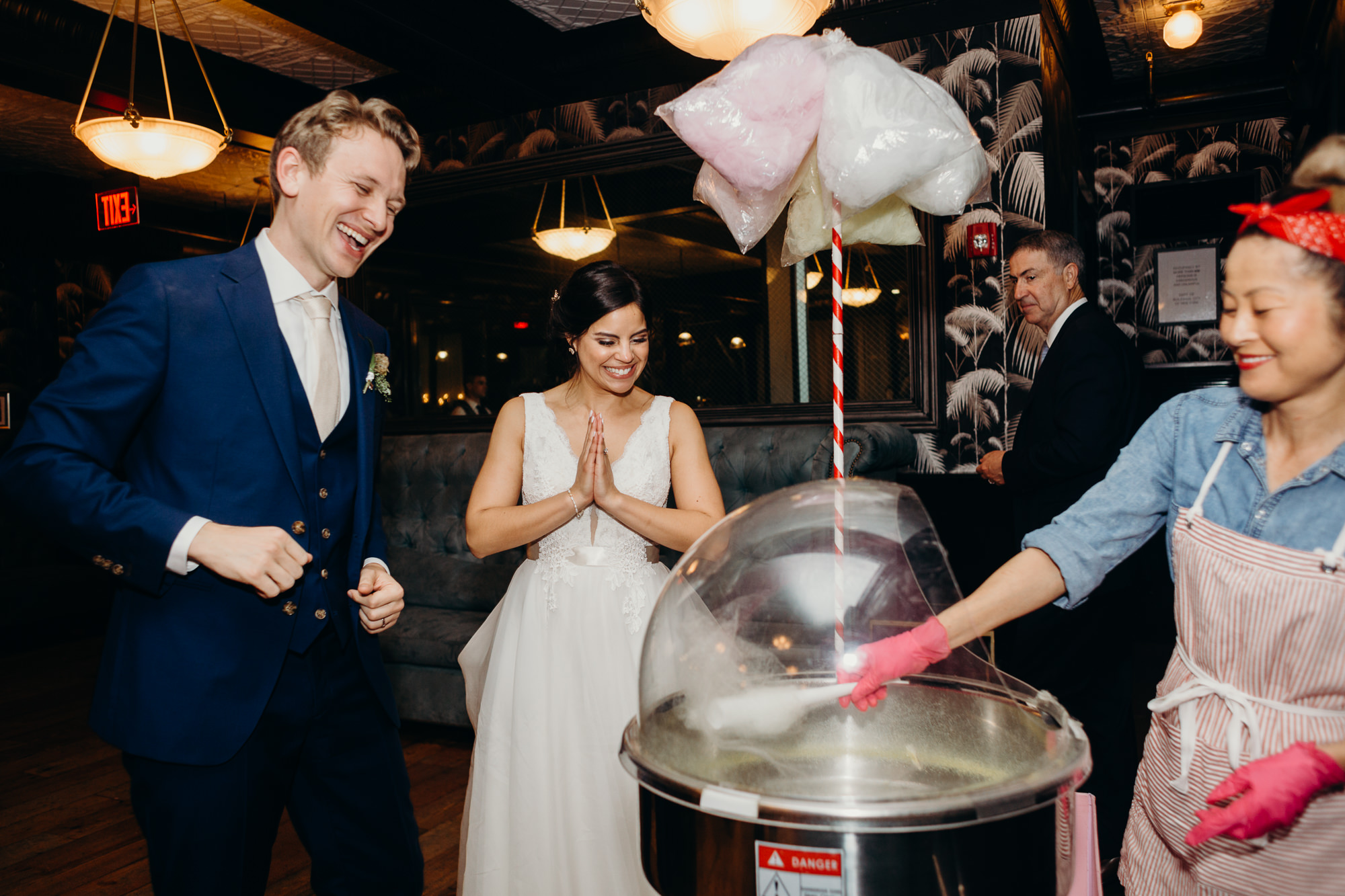 a bride and groom smile at cotton candy at their wedding reception at 501 union in brooklyn, ny