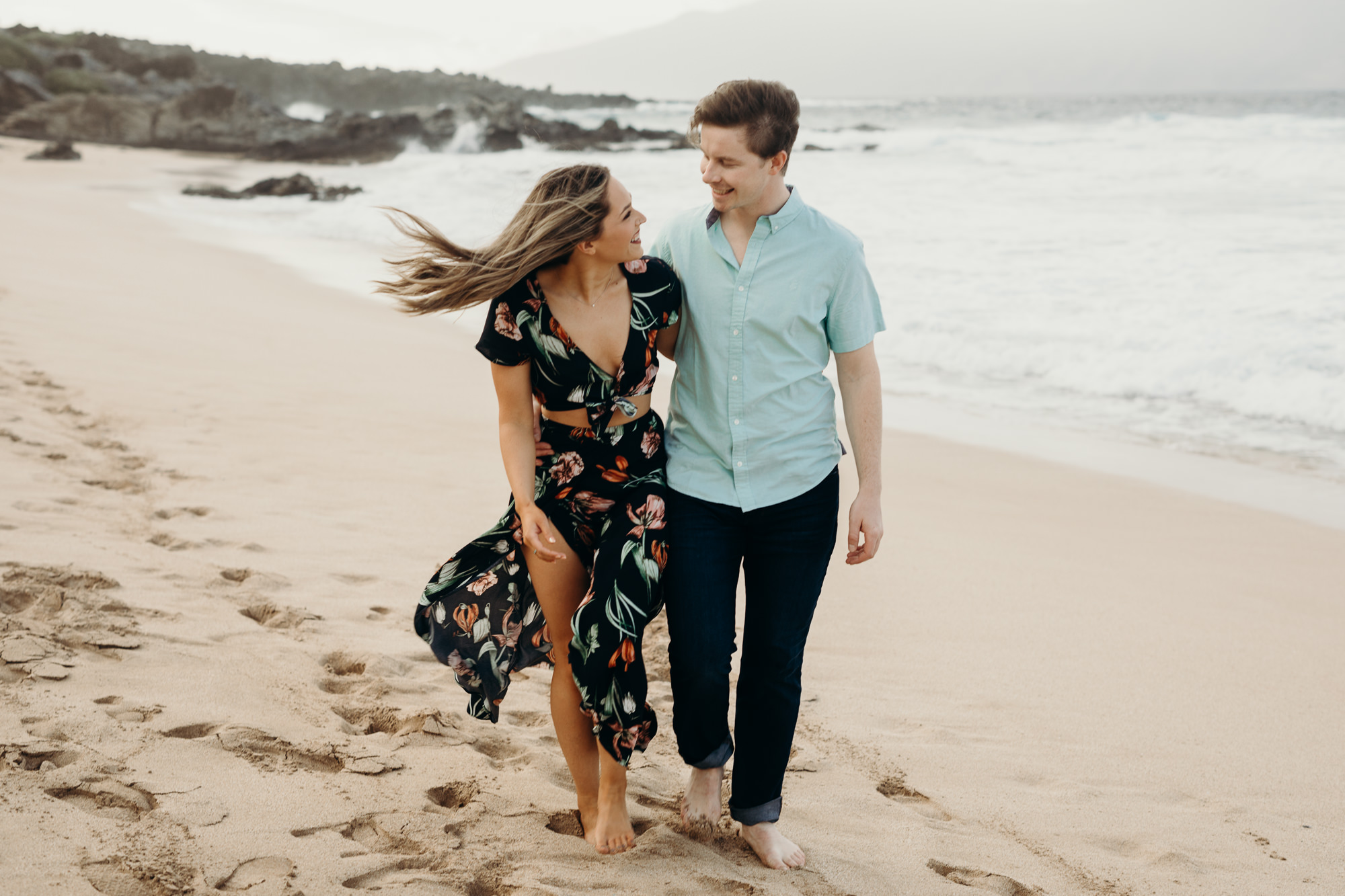 portrait of a couple walking and laughing on the beach in maui, HI