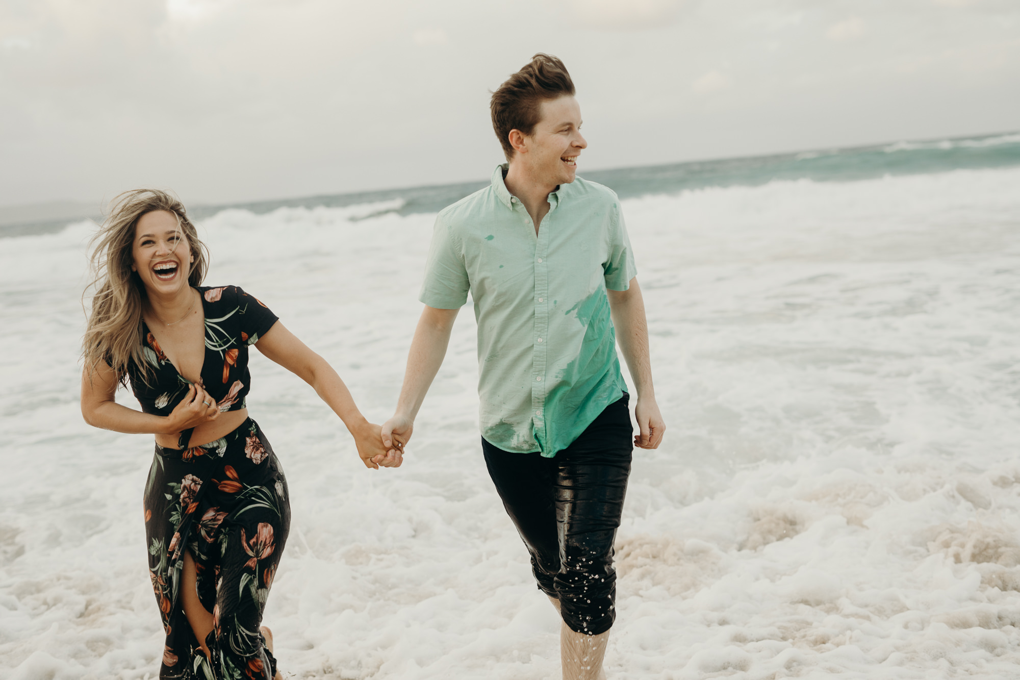 portrait of a couple running in the ocean in maui, HI