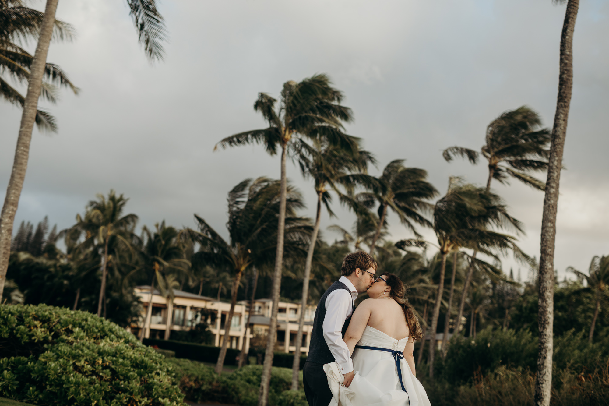 bride and groom kissing portrait with palm trees at merrimans maui in kaanapali, HI
