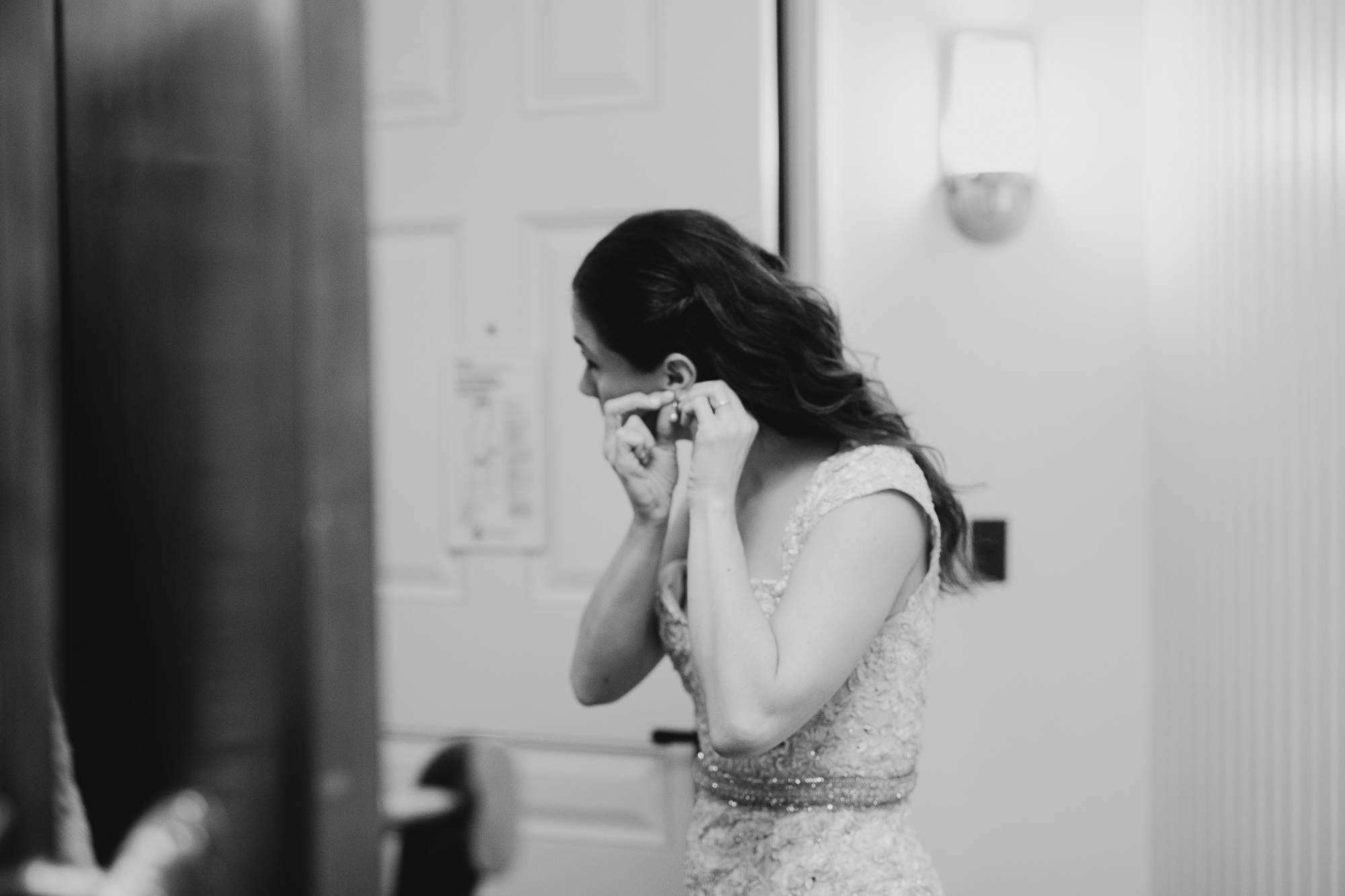 bride putting her earrings on at the beekman hotel in new york city, NY
