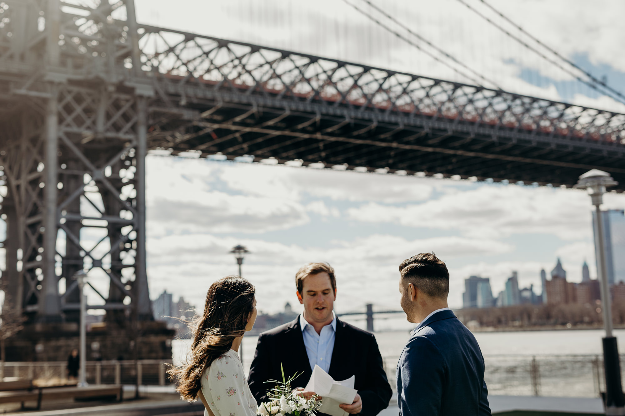 bride and groom during their wedding ceremony at domino park in brooklyn, ny