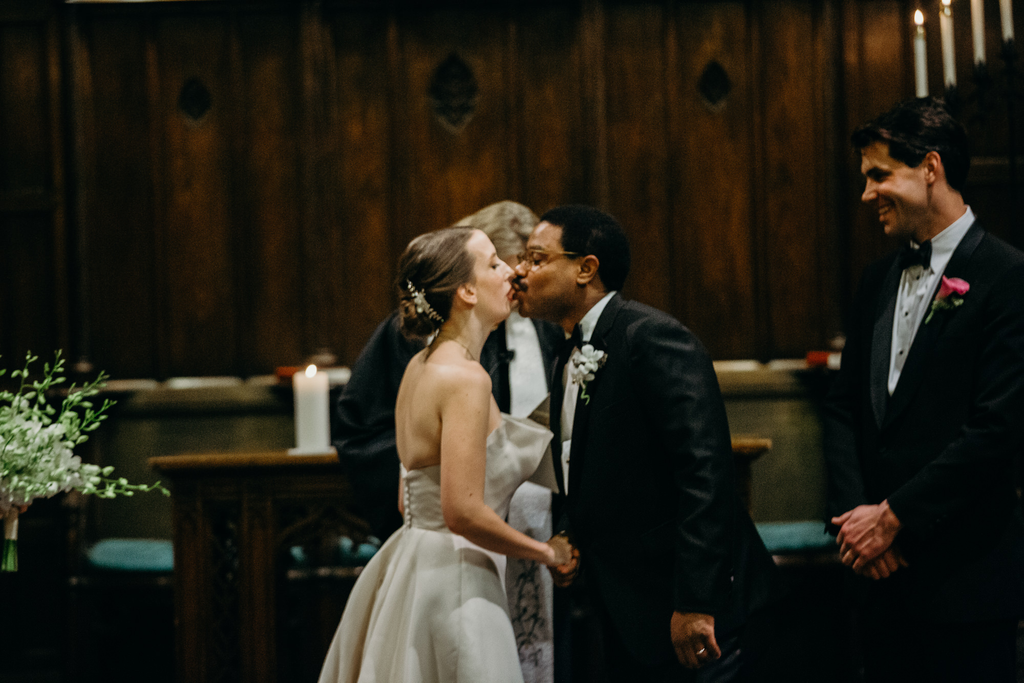 bride and groom kiss during their wedding ceremony at church in new york city, ny