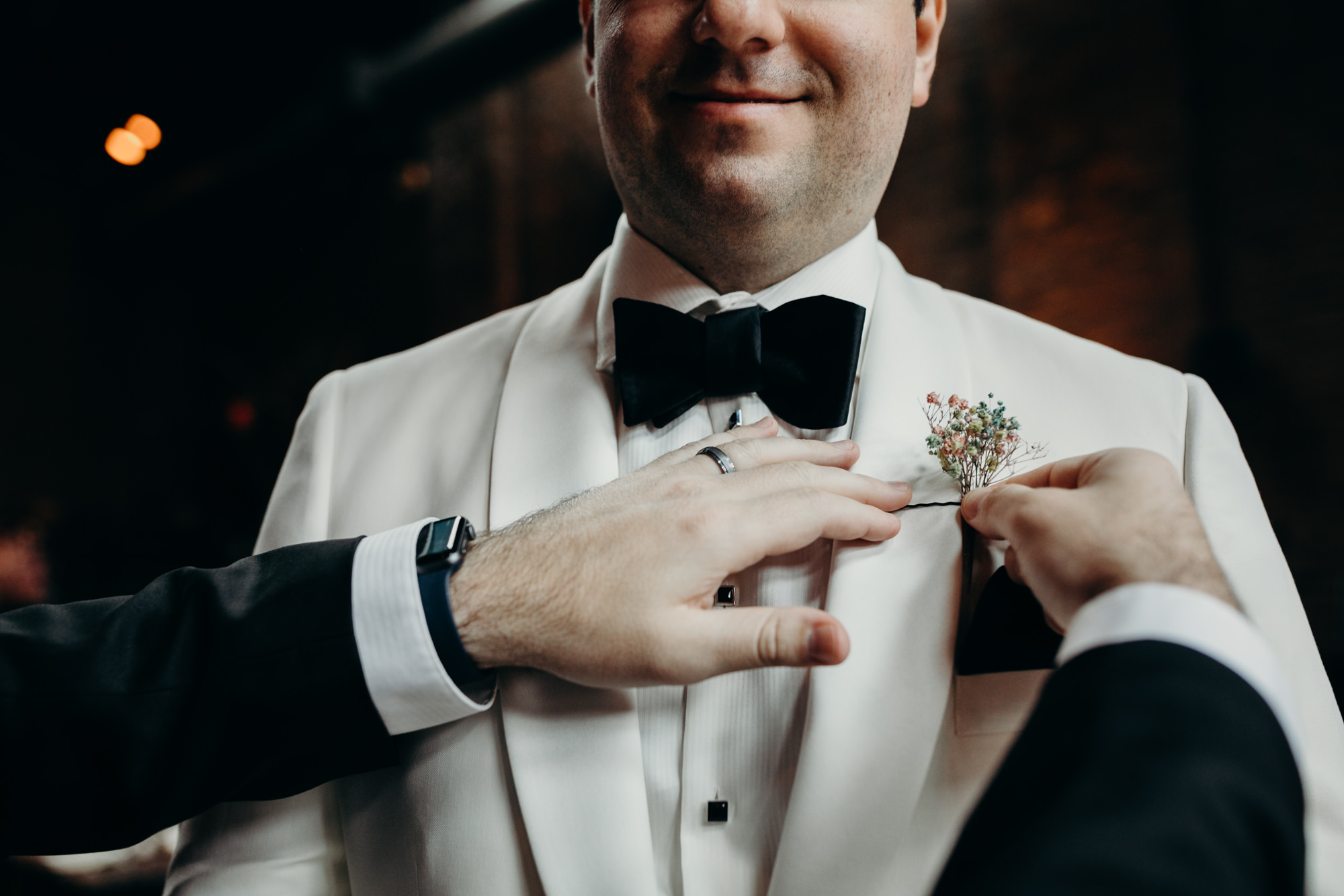 groom adjusting his boutonniere at mymoon in brooklyn, new york