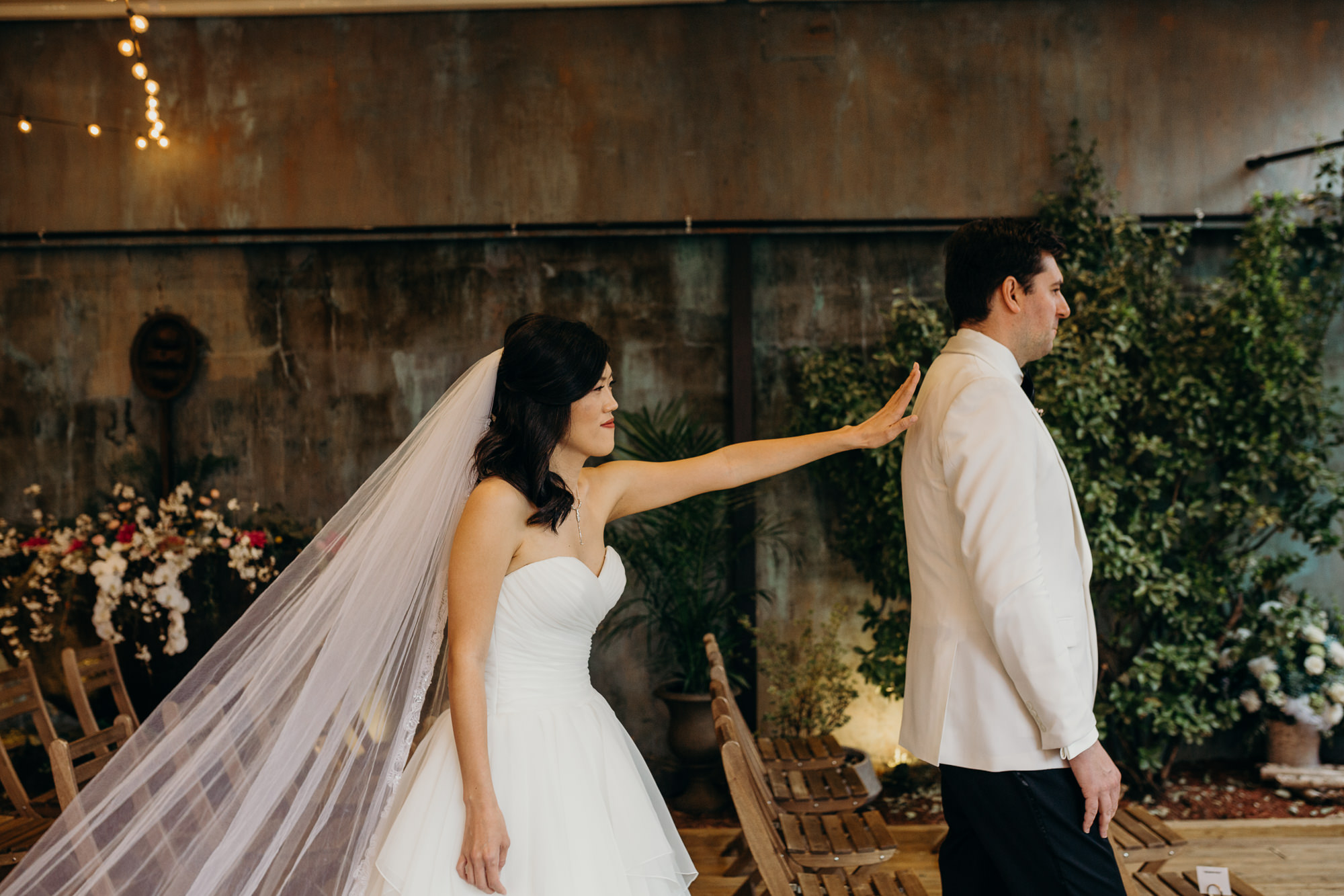 bride taps her groom on the shoulder for their first look at mymoon in brooklyn, new york