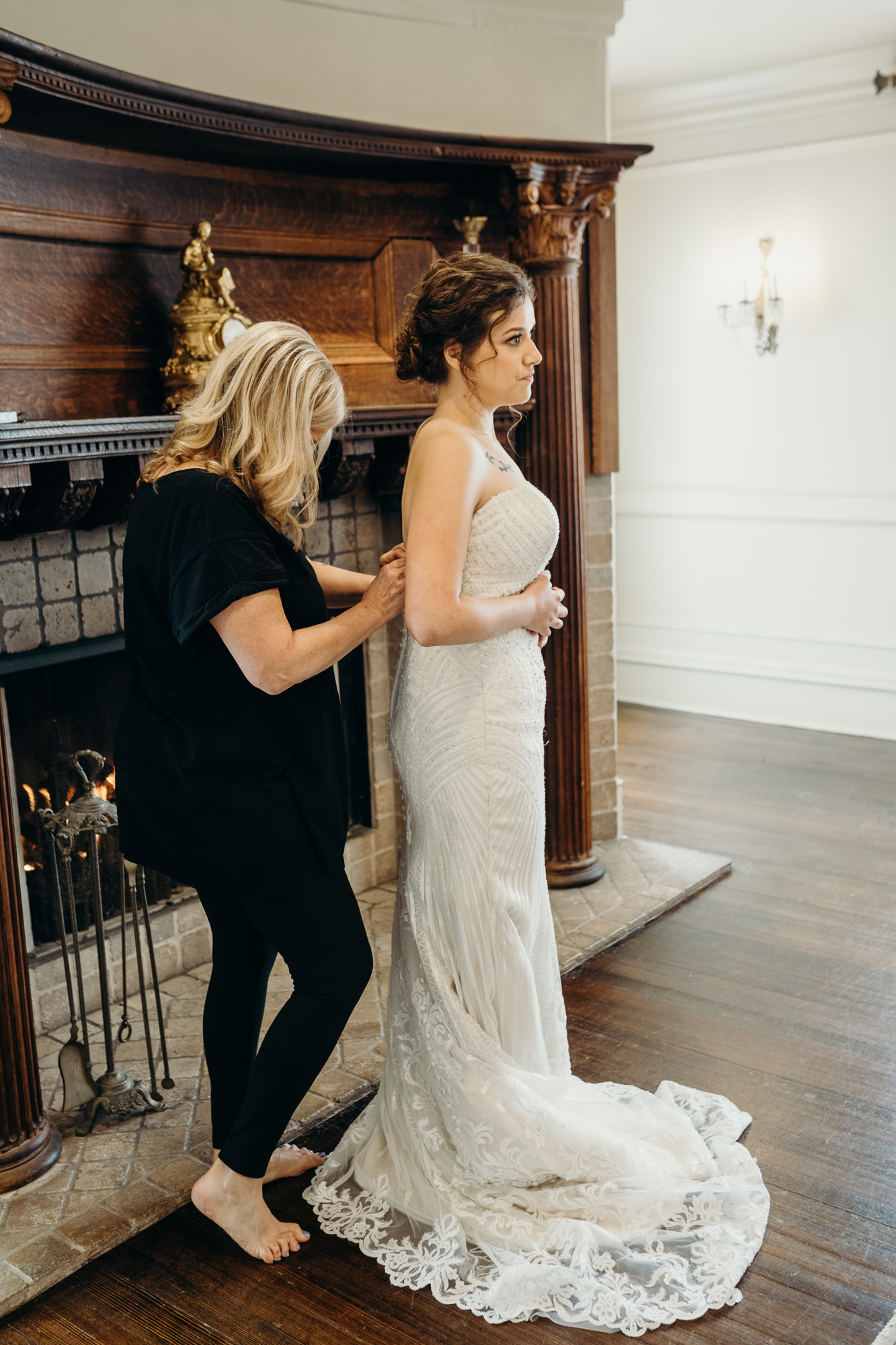 portrait of a bride getting into her wedding dress at the park savoy in florham park, new jersey