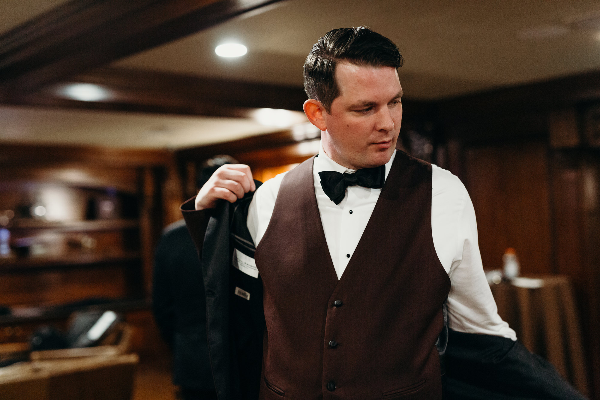 groom putting on his jacket at the park savoy in florham park, new jersey