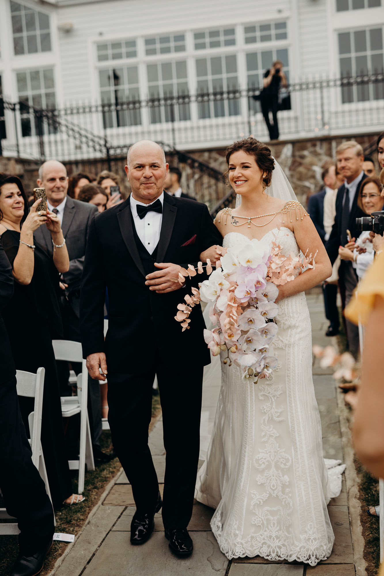 a bride walks down the aisle with her father at the park savoy in florham park, new jersey