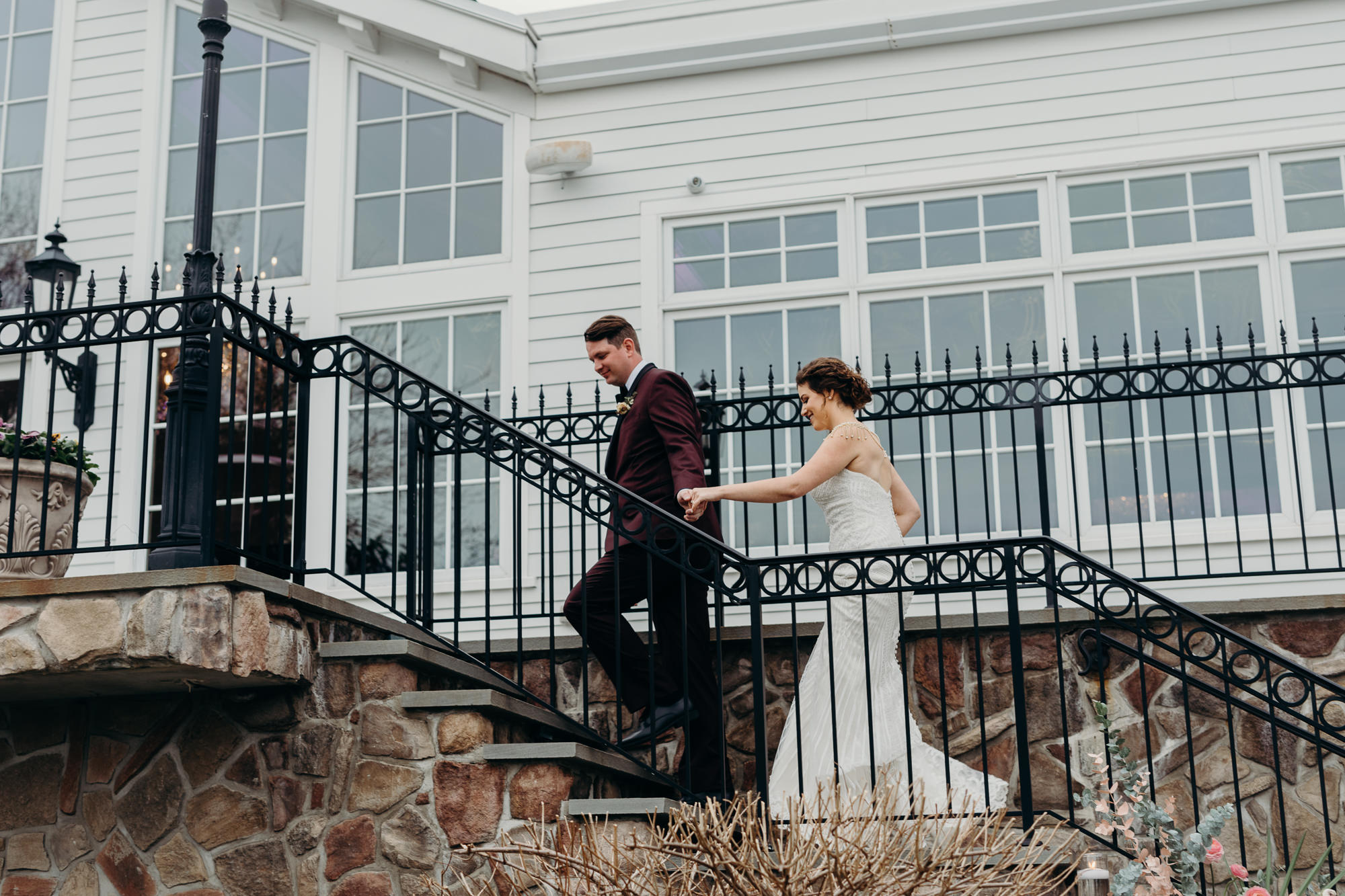 a bride and groom walk up stairs at the park savoy in florham park, new jersey