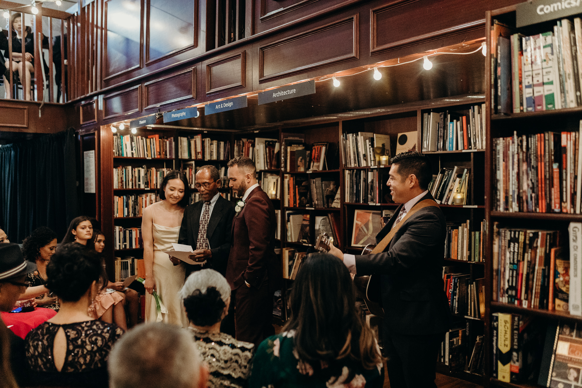 a bride and groom during their wedding ceremony at housingworks bookstore in new york, new york