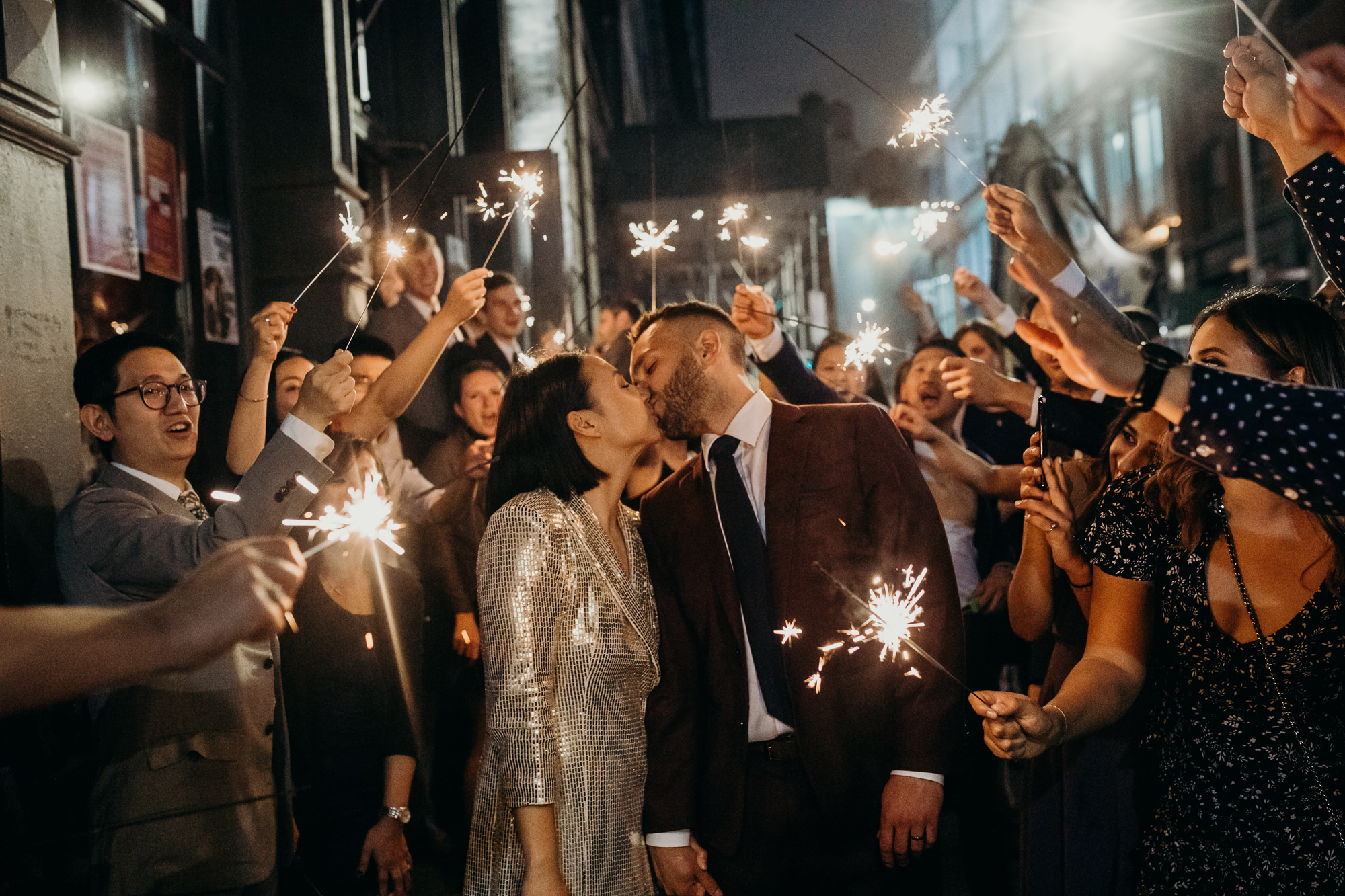 a bride and groom have a sparkler exit at housingworks bookstore in new york, new york