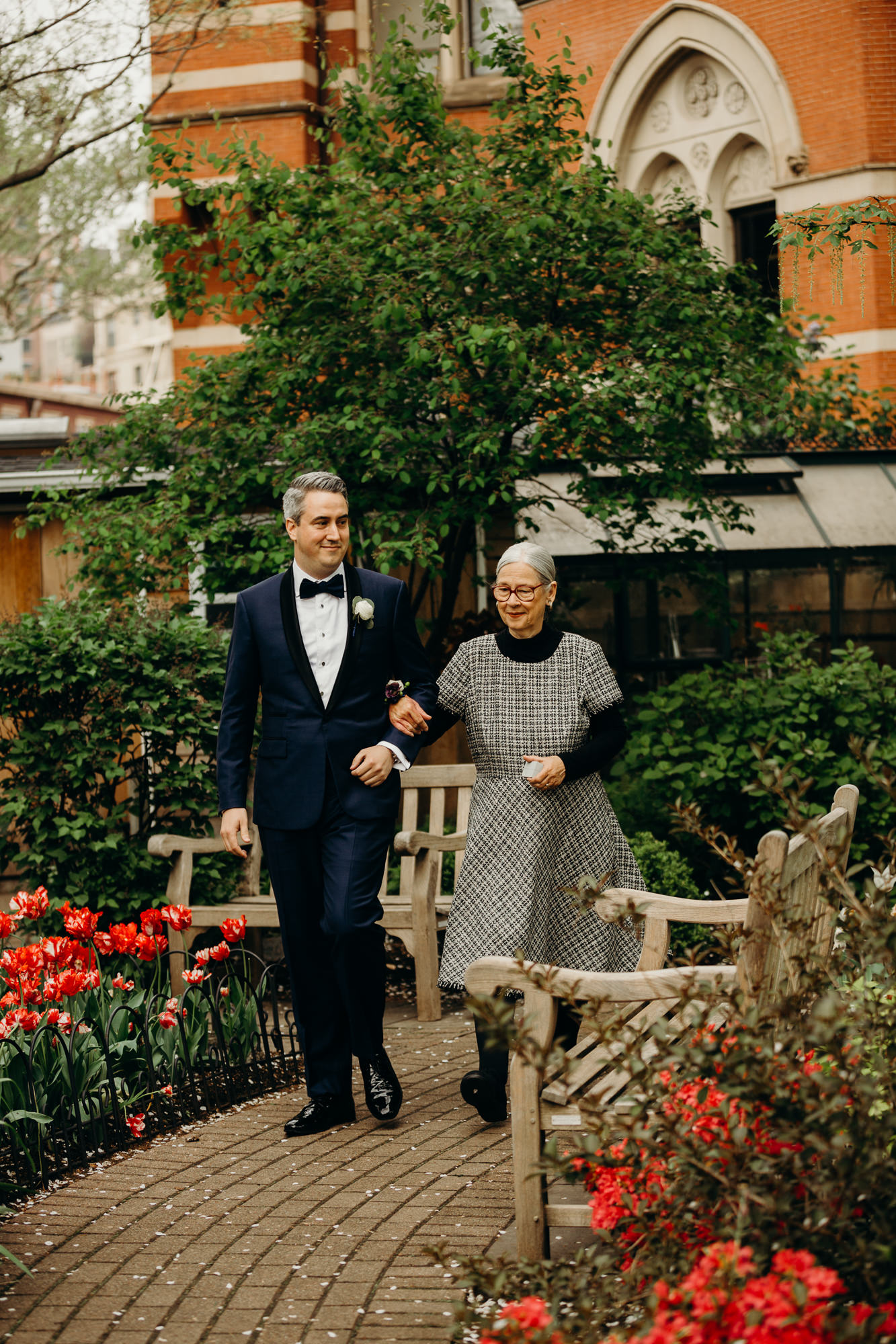 a groom walks to his wedding at jefferson market garden in the west village, new york city