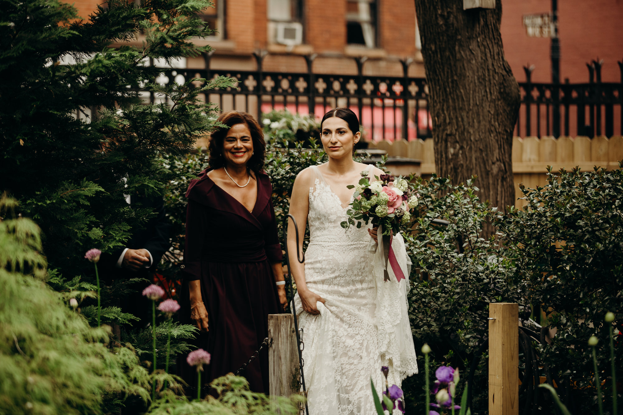 a bride walks to her wedding at jefferson market garden in the west village, new york city