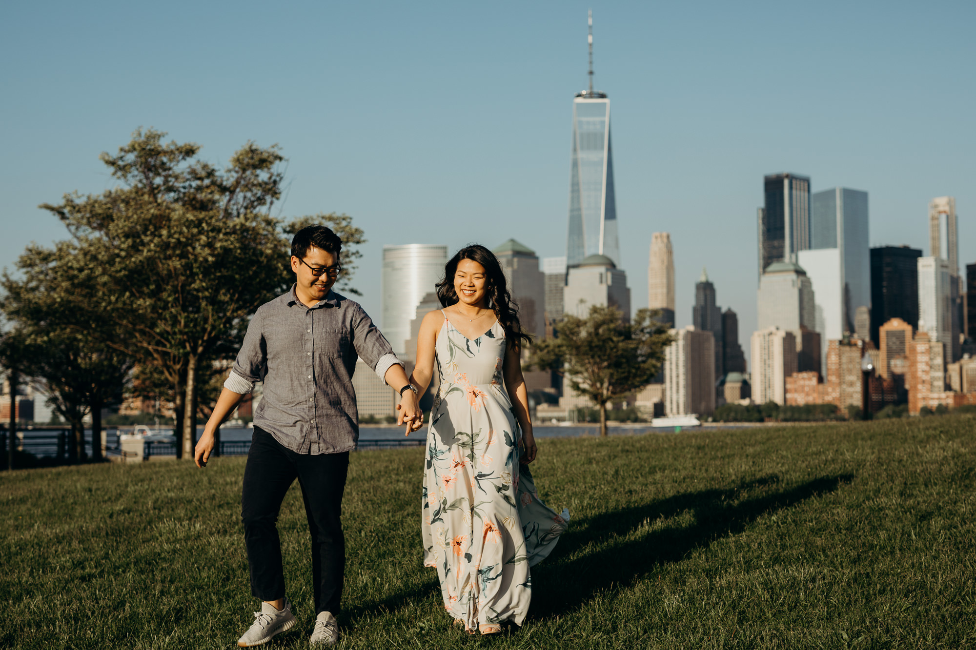 a portrait of a couple against the nyc skyline at liberty state park in jersey city, new jersey