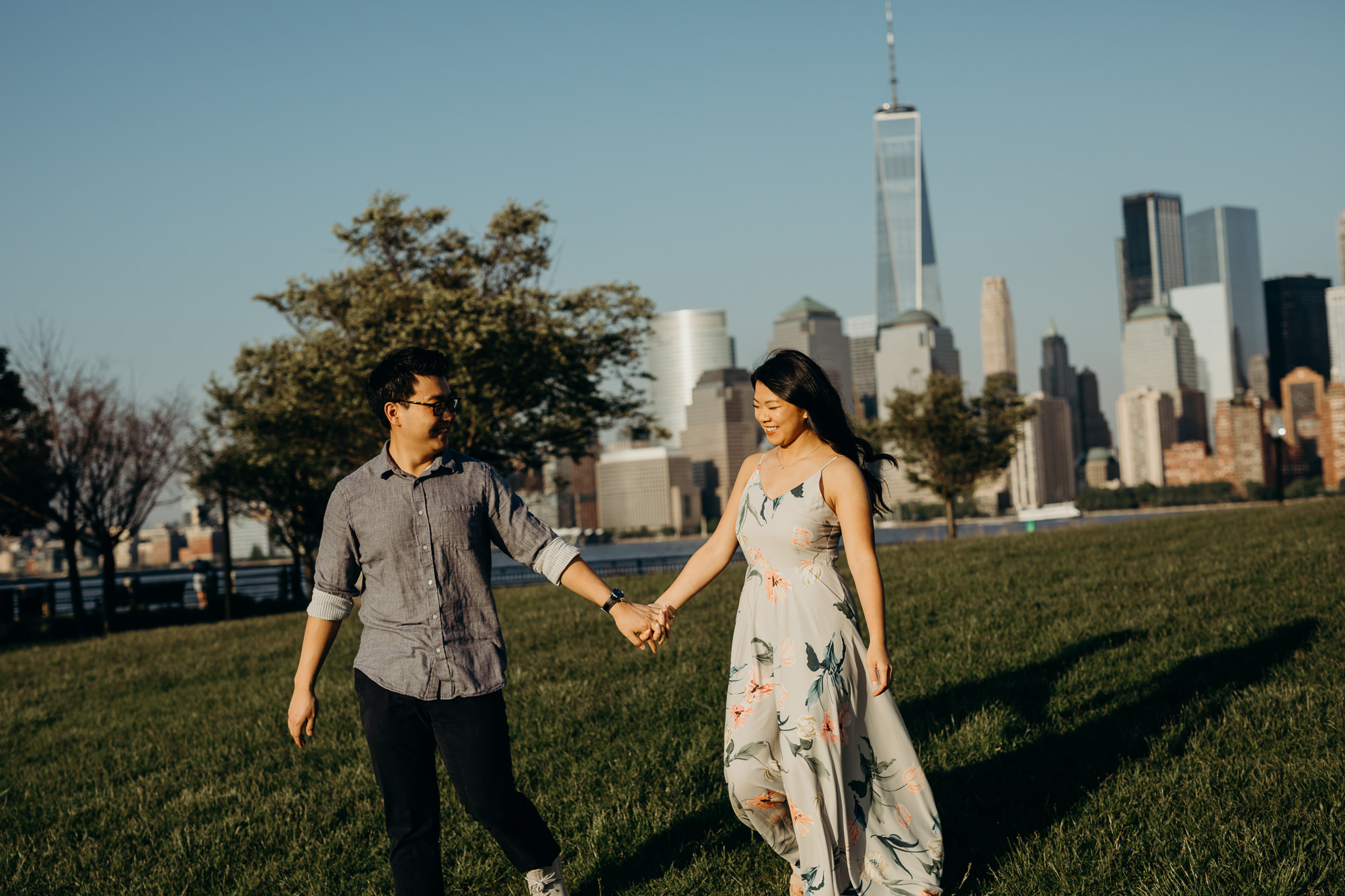 a portrait of a couple against the nyc skyline at liberty state park in jersey city, new jersey