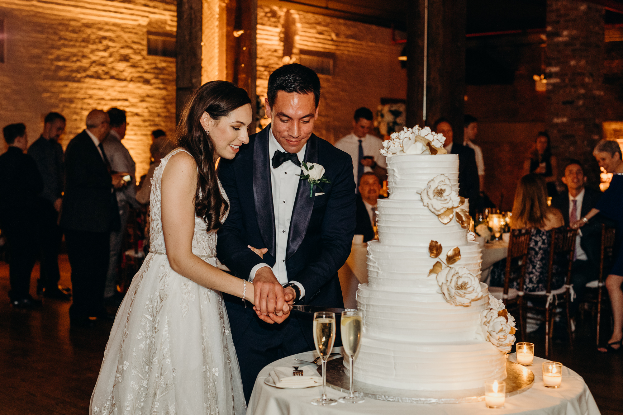 a bride and groom cut their wedding cake at liberty warehouse in brooklyn, new york city