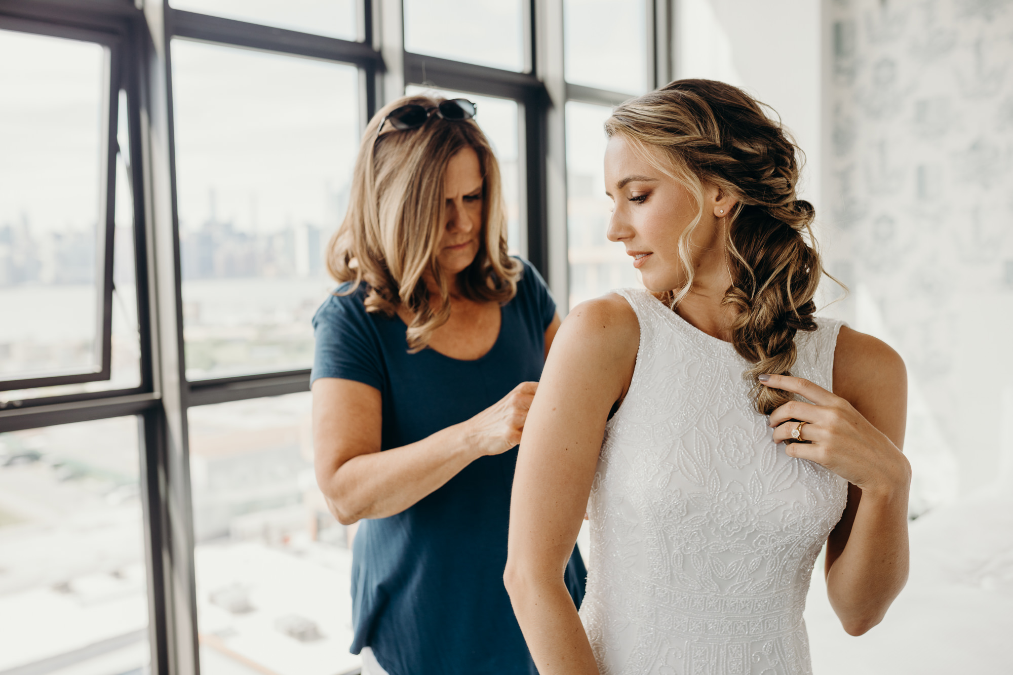a bride getting into her wedding gown at the wythe hotel in brooklyn, new york city