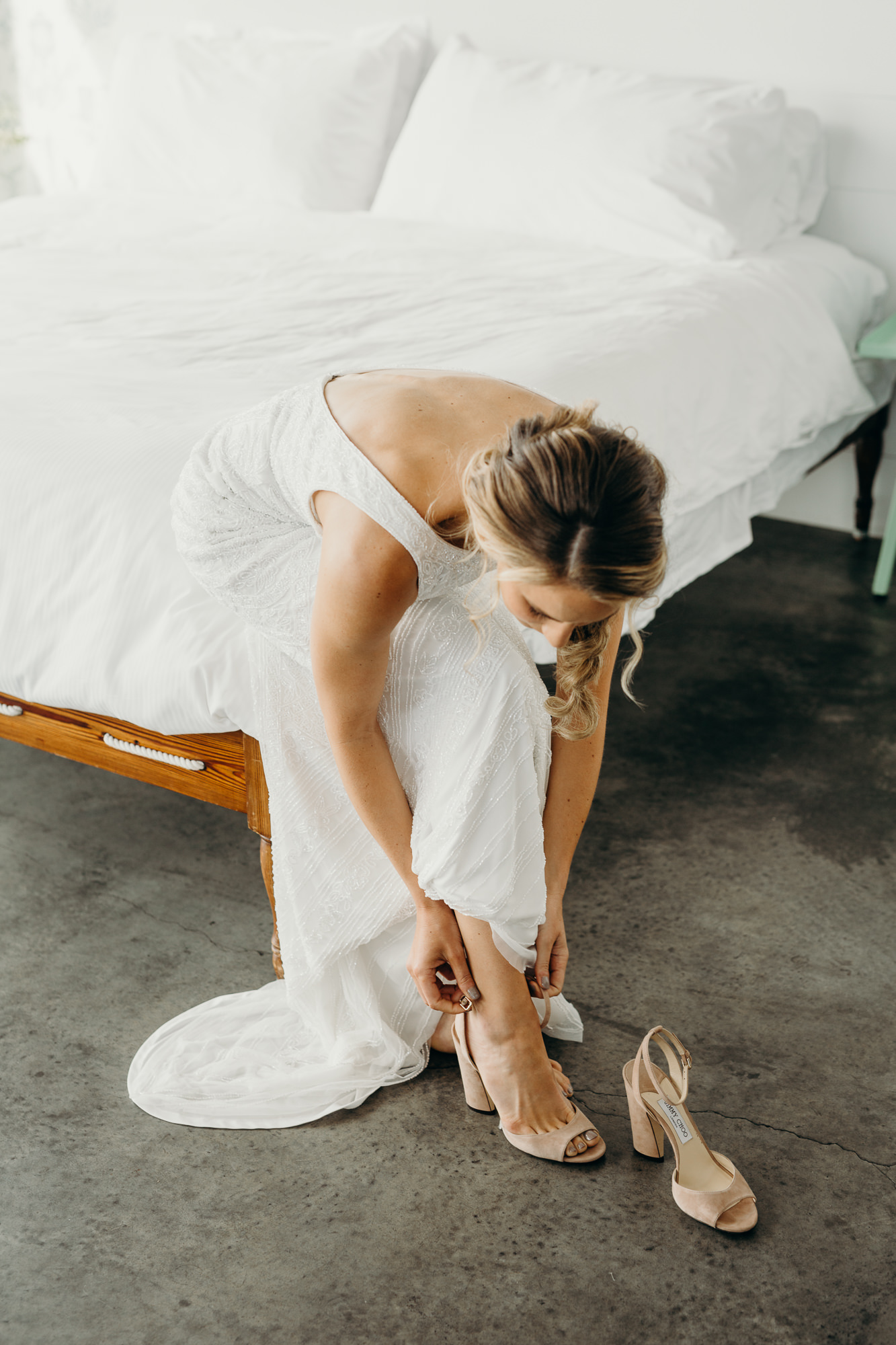 a bride putting on her wedding shoe at the wythe hotel in brooklyn, new york city