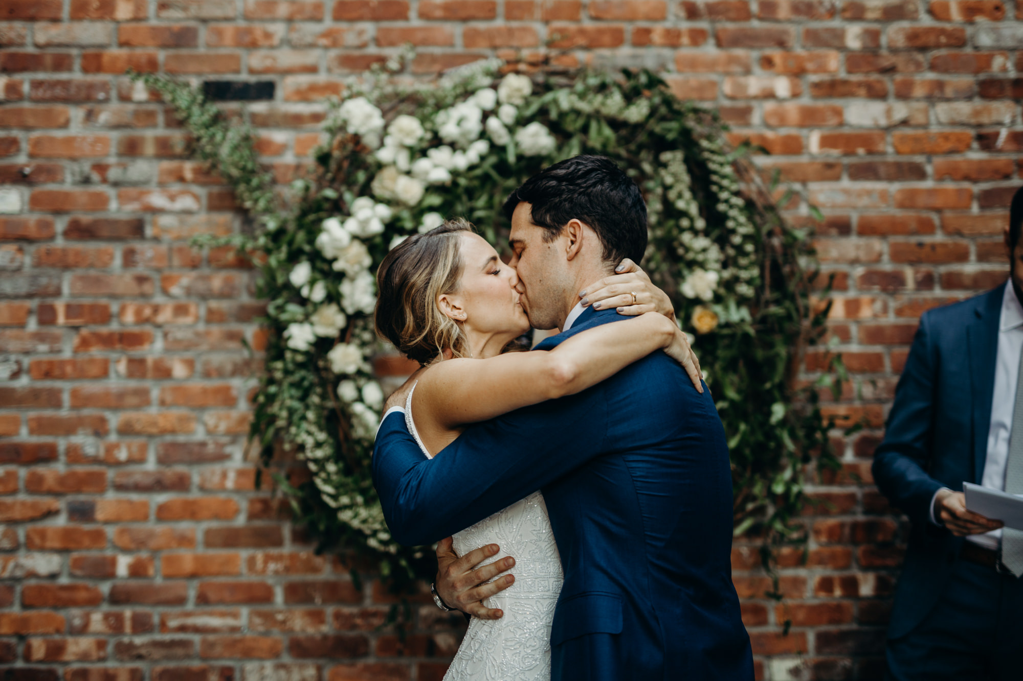 a bride and groom kiss at a wedding ceremony at the wythe hotel in brooklyn, new york city