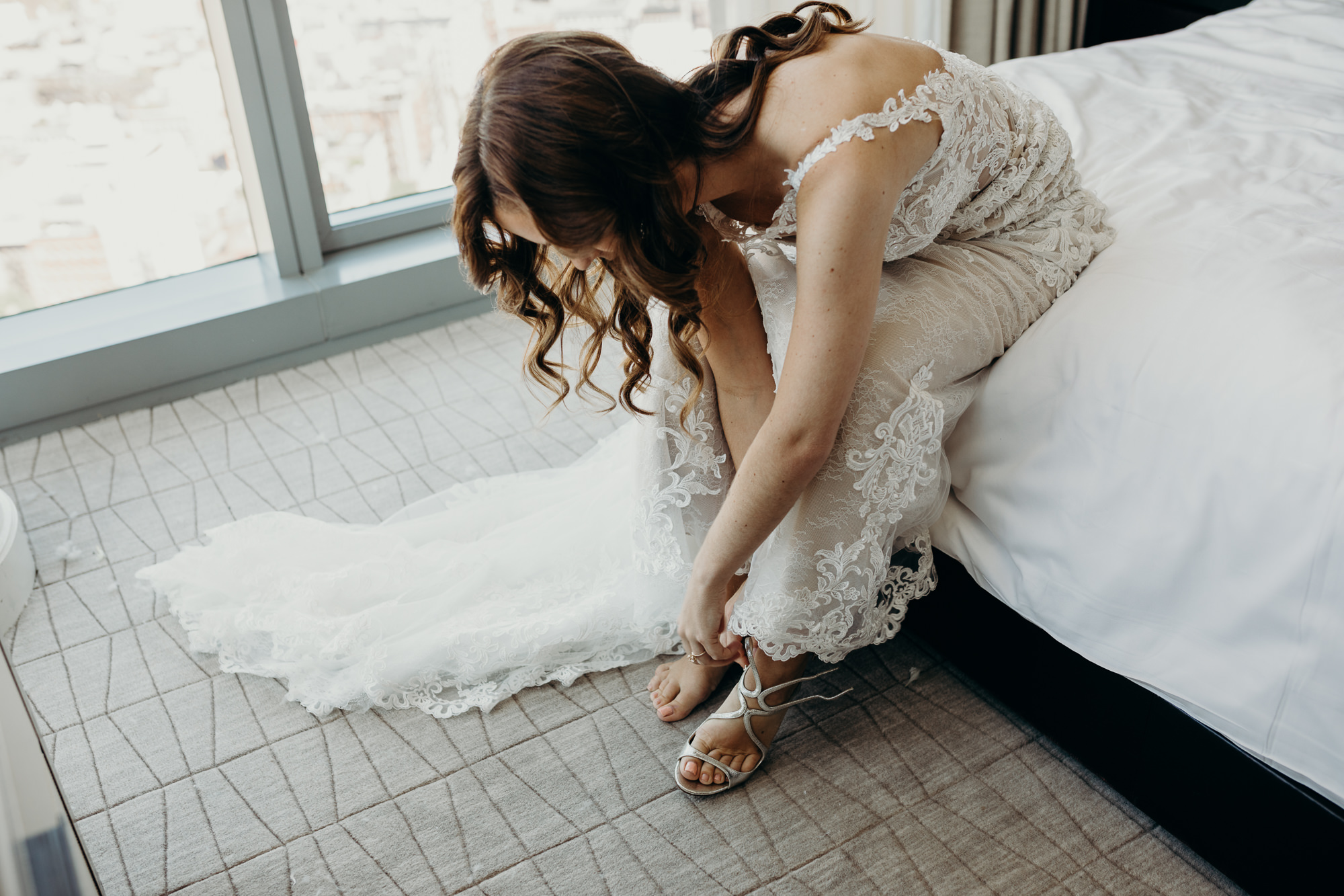 a portrait of a bride getting into her wedding dress at city winery in new york city