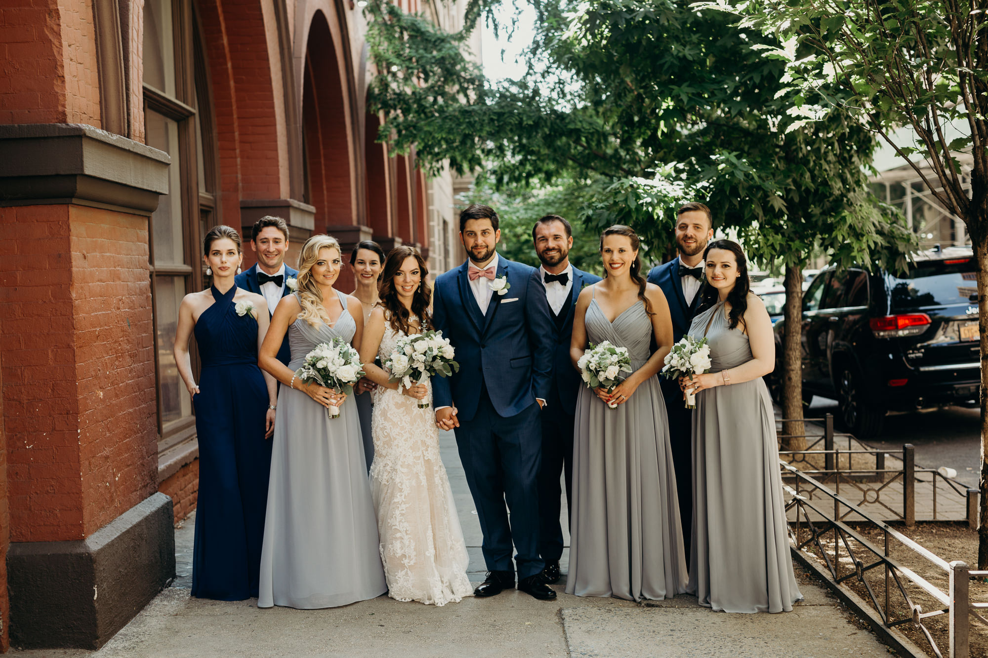 a portrait of a bride and groom with their wedding party at city winery in new york city, new york