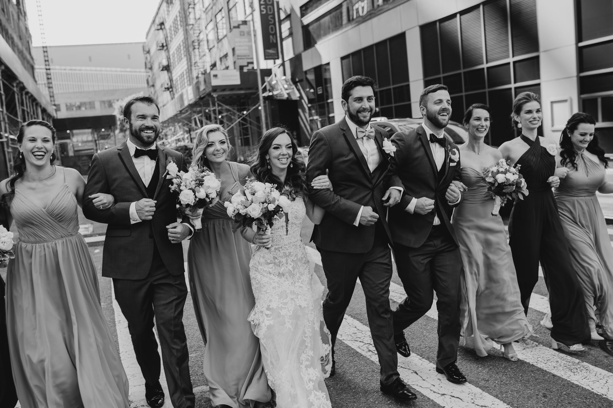 a portrait of a bride and groom with their wedding party at city winery in new york city, new york