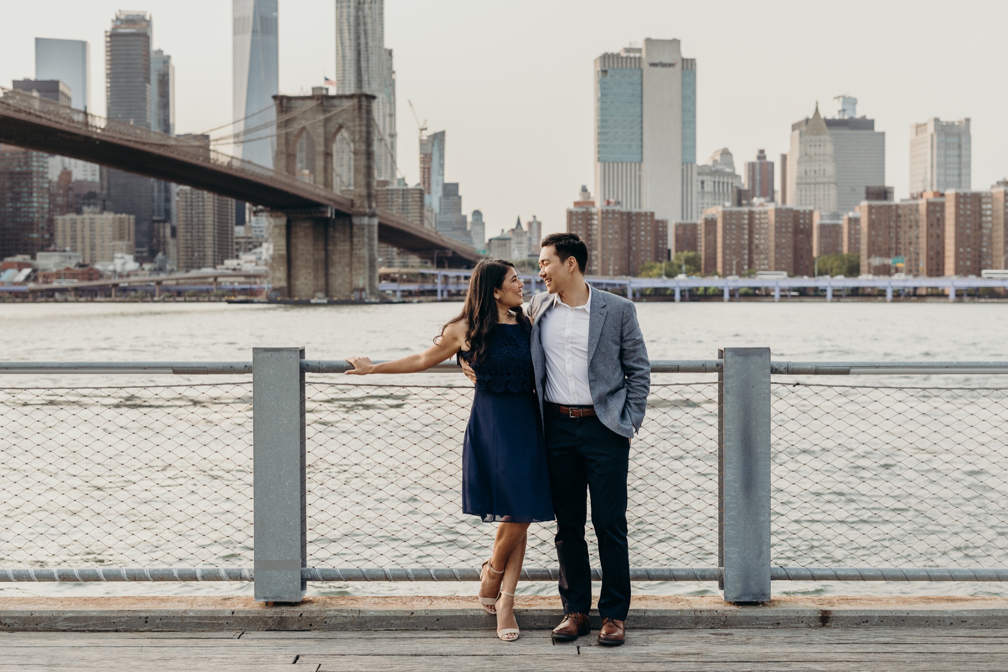 engagement photos of a couple in front of the brooklyn bridge, dumbo