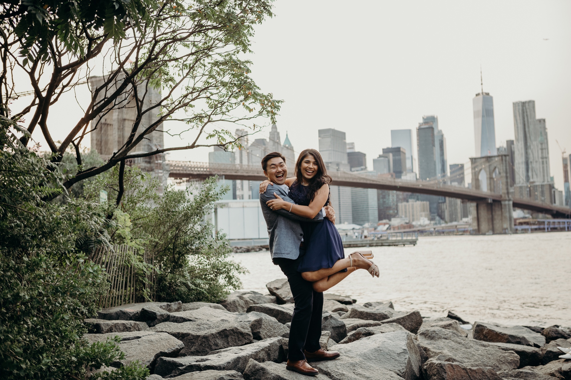 engagement photos of a couple in front of the brooklyn bridge, dumbo