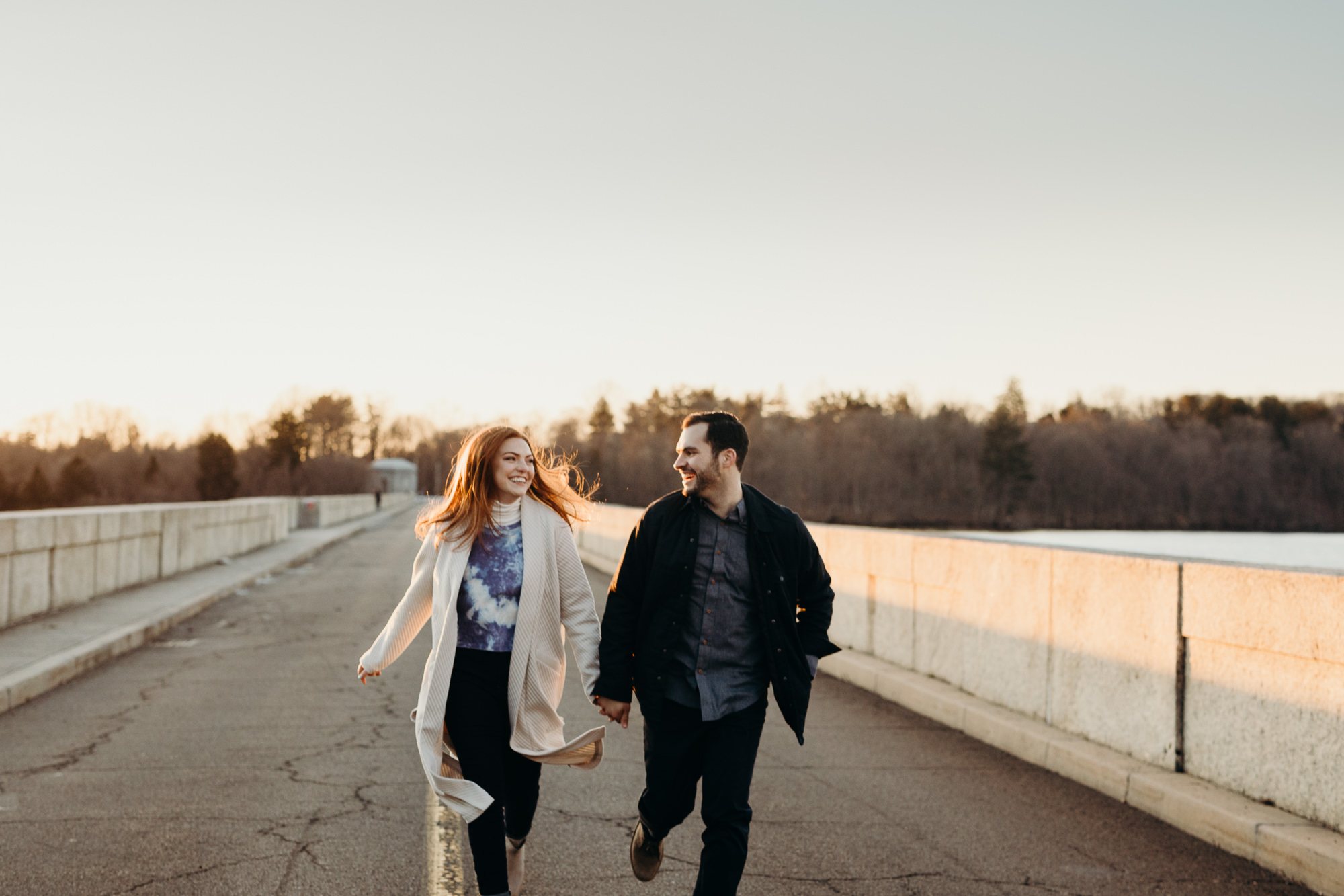 a couple running together during sunset at their engagement session in new york cuty