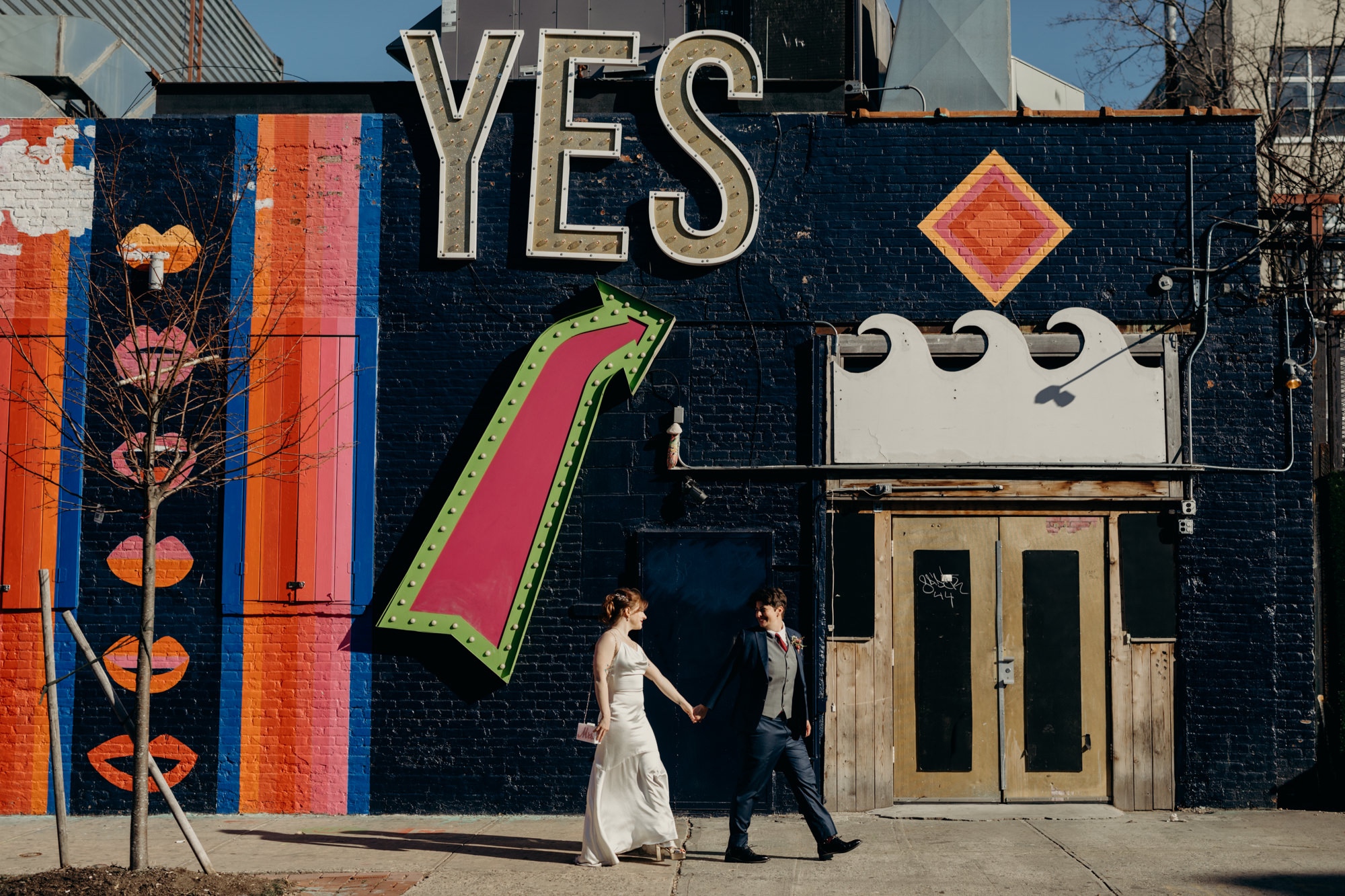 portrait of a couple walking together outside the house of yes in bushwick, brooklyn, new york city