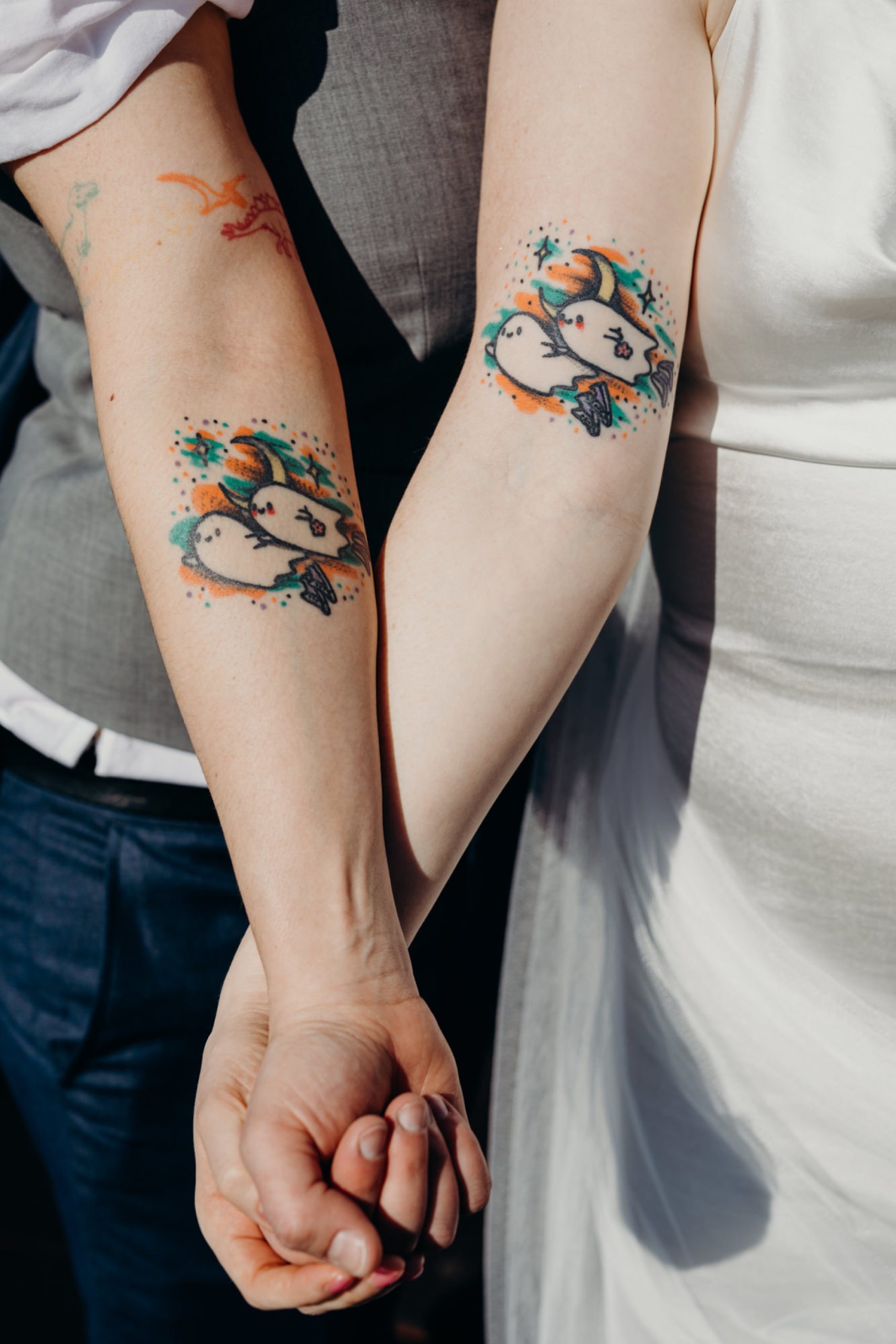 a wedding couple shows off matching ghost tattoos