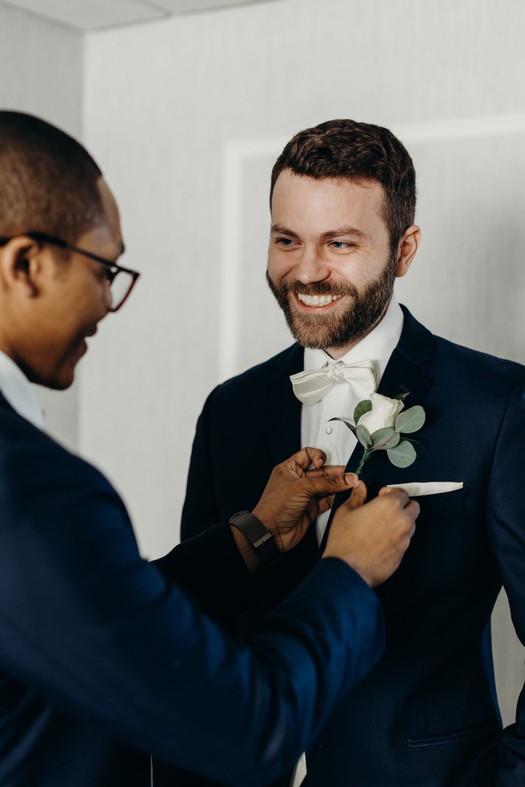 groom putting on a boutonniere on his wedding day at valley regency in new jersye