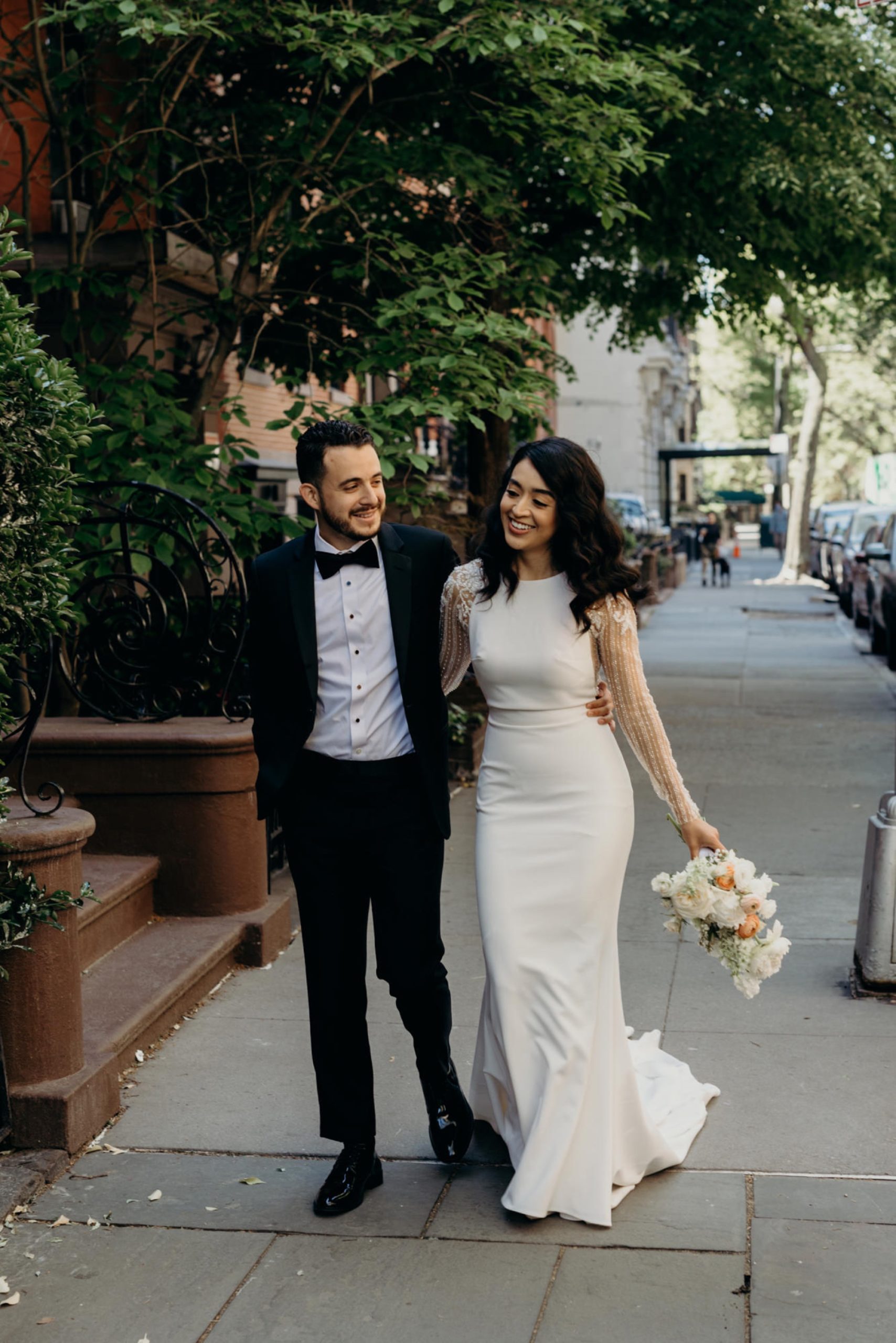 portrait of a bride and groom walking and laughing on their wedding day in brooklyn, new york city