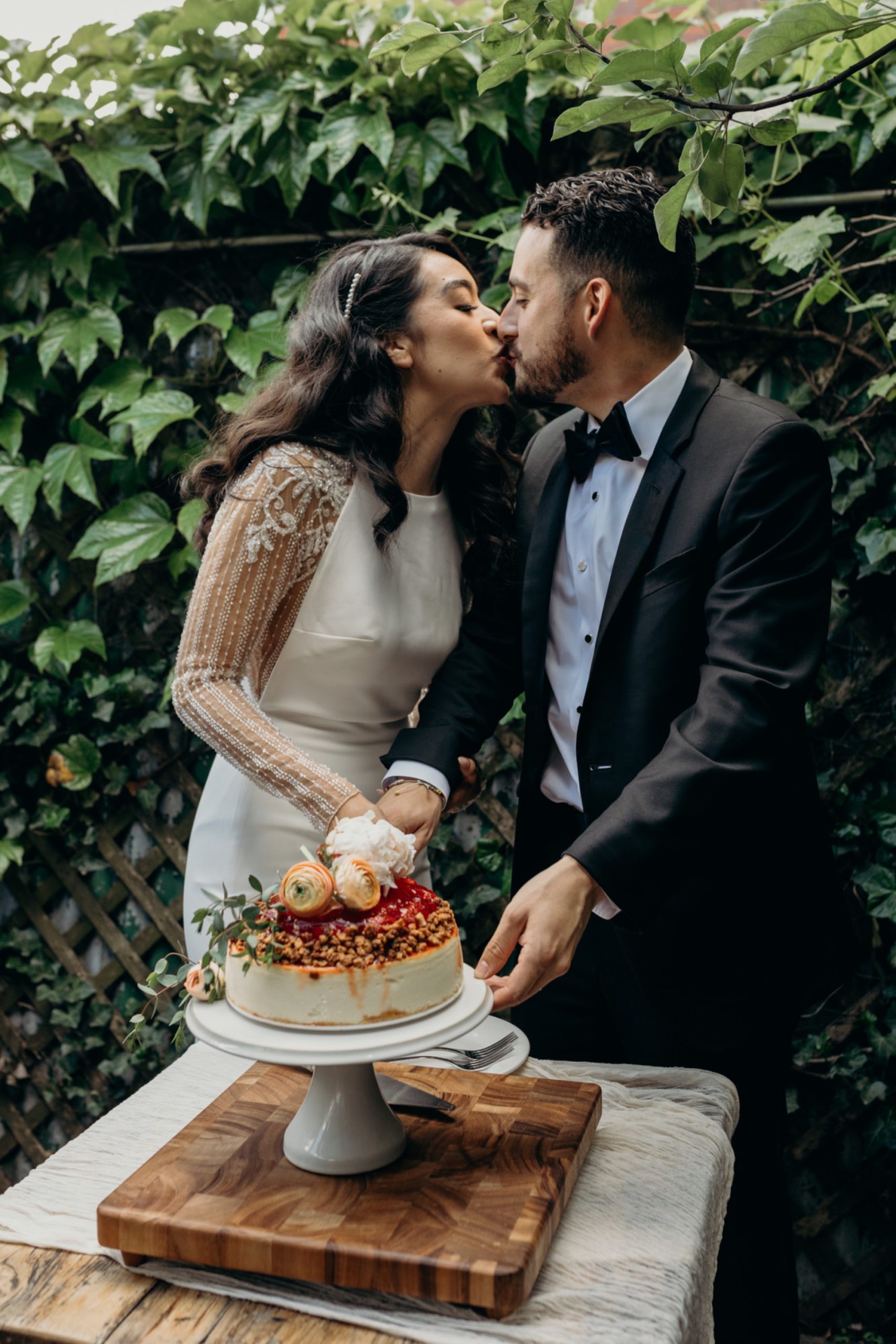 bride and groom cut their wedding cake during their reception at aurora in brooklyn, new york city