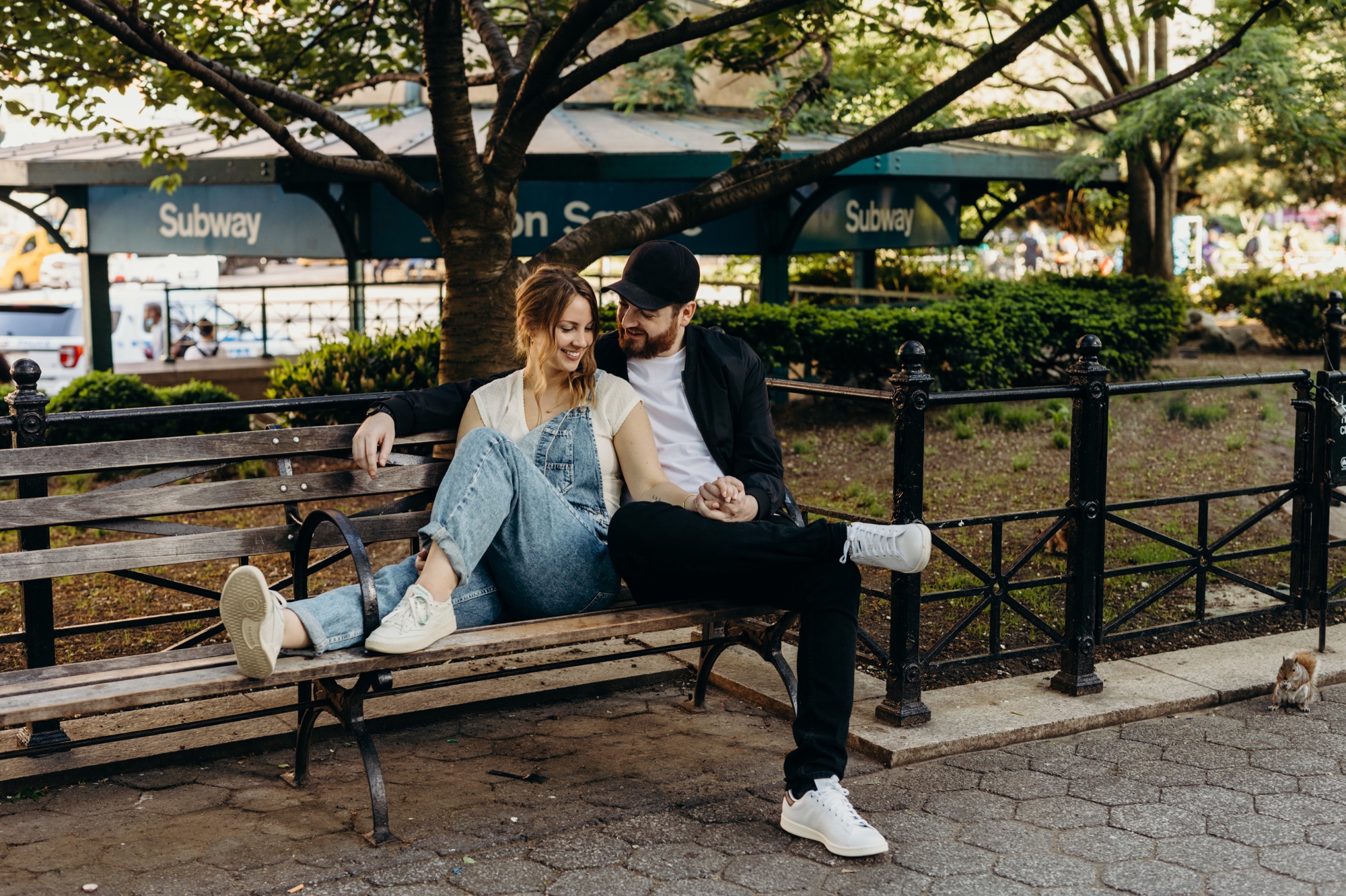 portrait of a couple sitting on a bench in union square during their engagement session in new york city