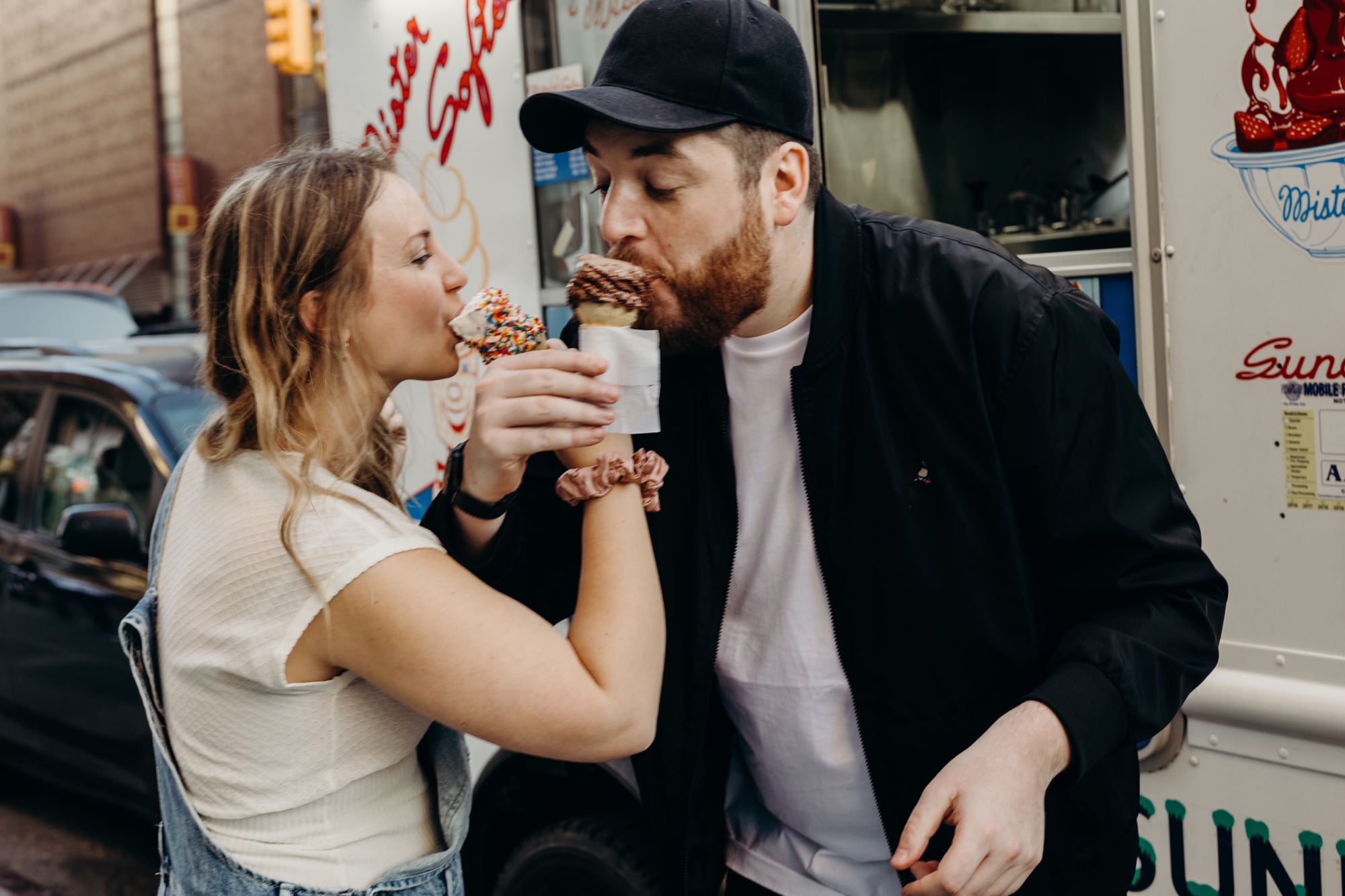 portrait of a couple eating ice cream during their engagement session at mister softee in new york city