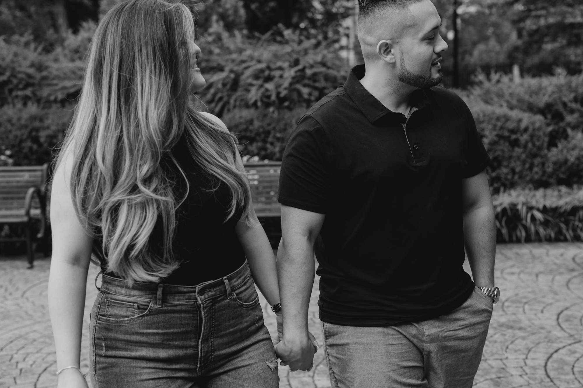 black and white photo of a couple holding hands and walking together