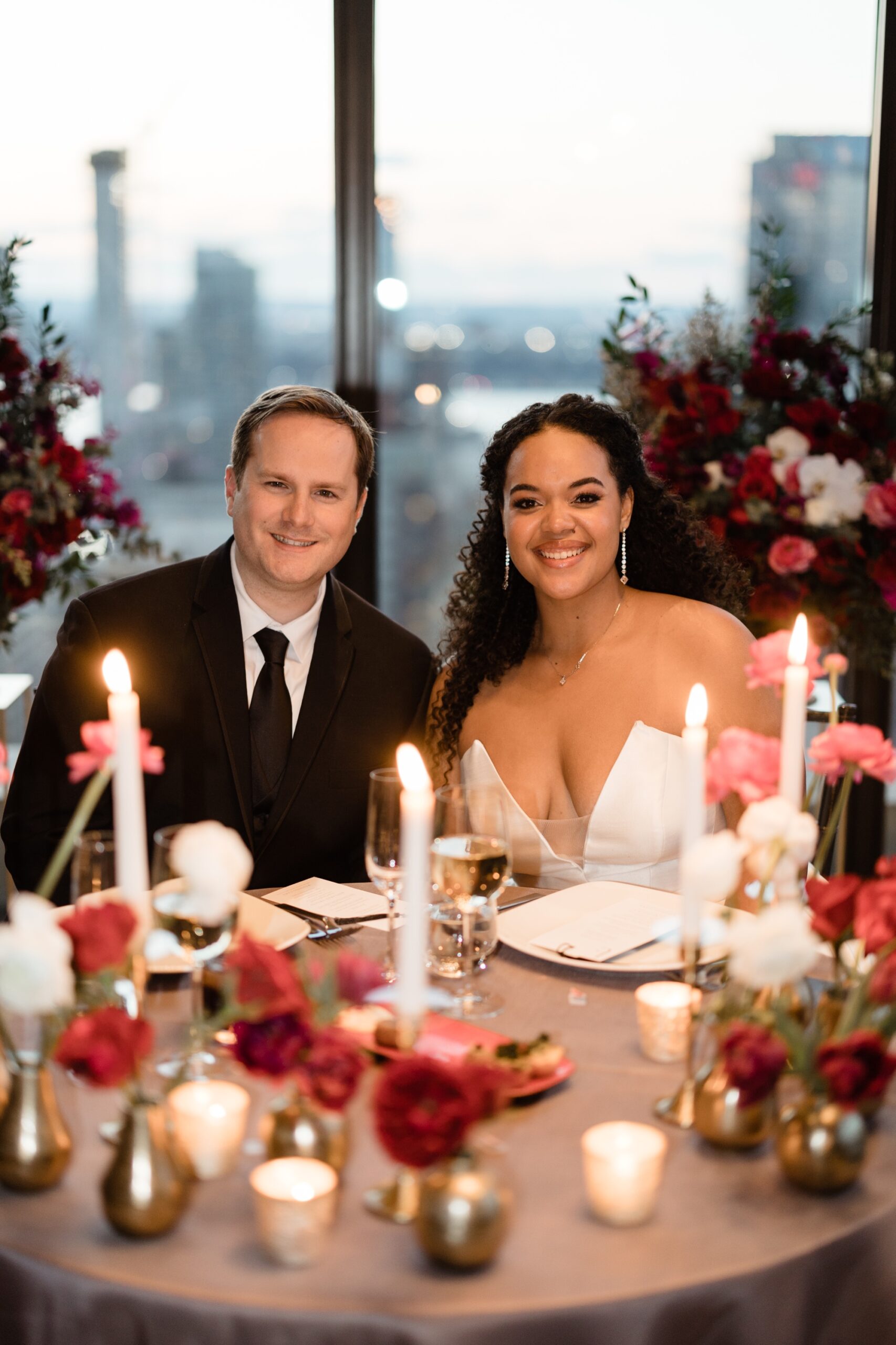 candlelit portrait of couple sitting at their sweetheart table