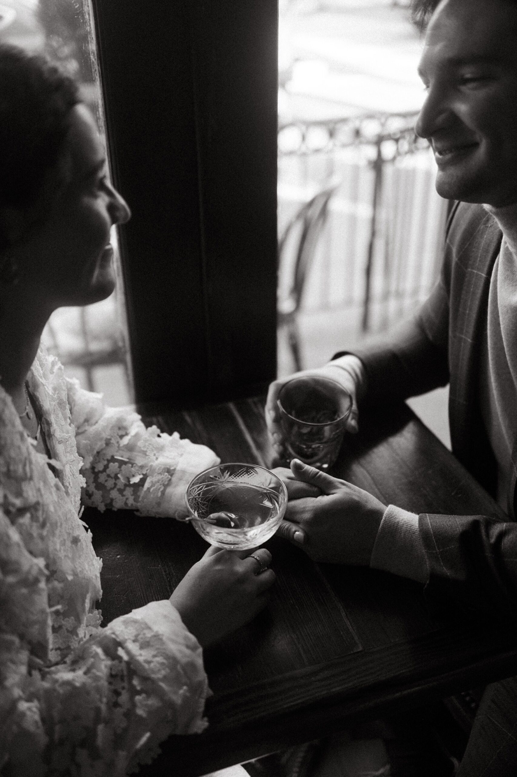 a black and white photo of a couple holding drinks at a bar in hoboken, new jersey