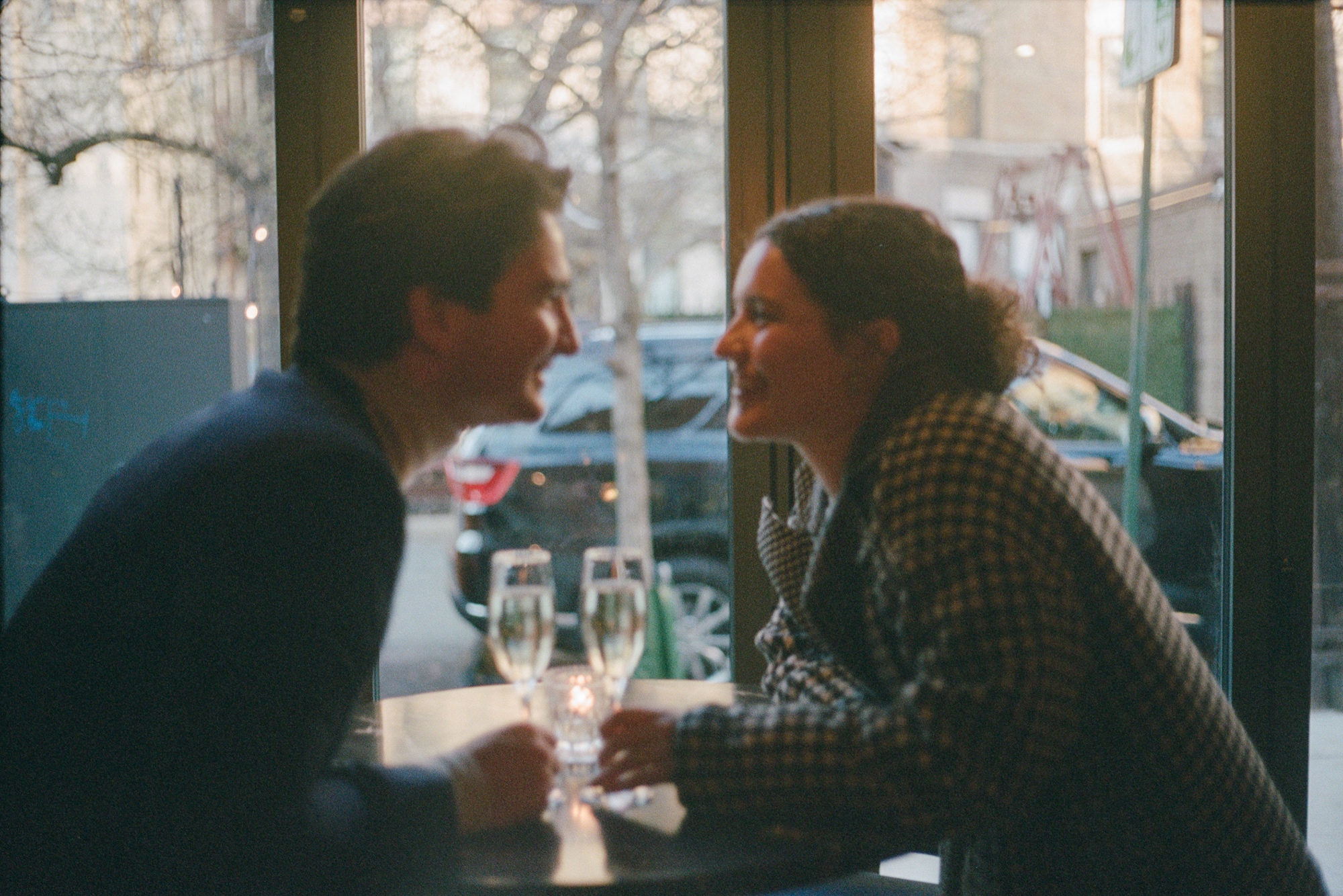 a blurry film photo of a couple sitting in front of a window in hoboken, new jersey